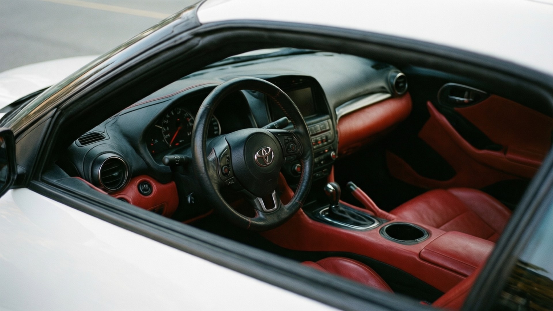 白色 Toyota Supra GR 的內裝視角，搭配搶眼的紅色皮革。 壁紙