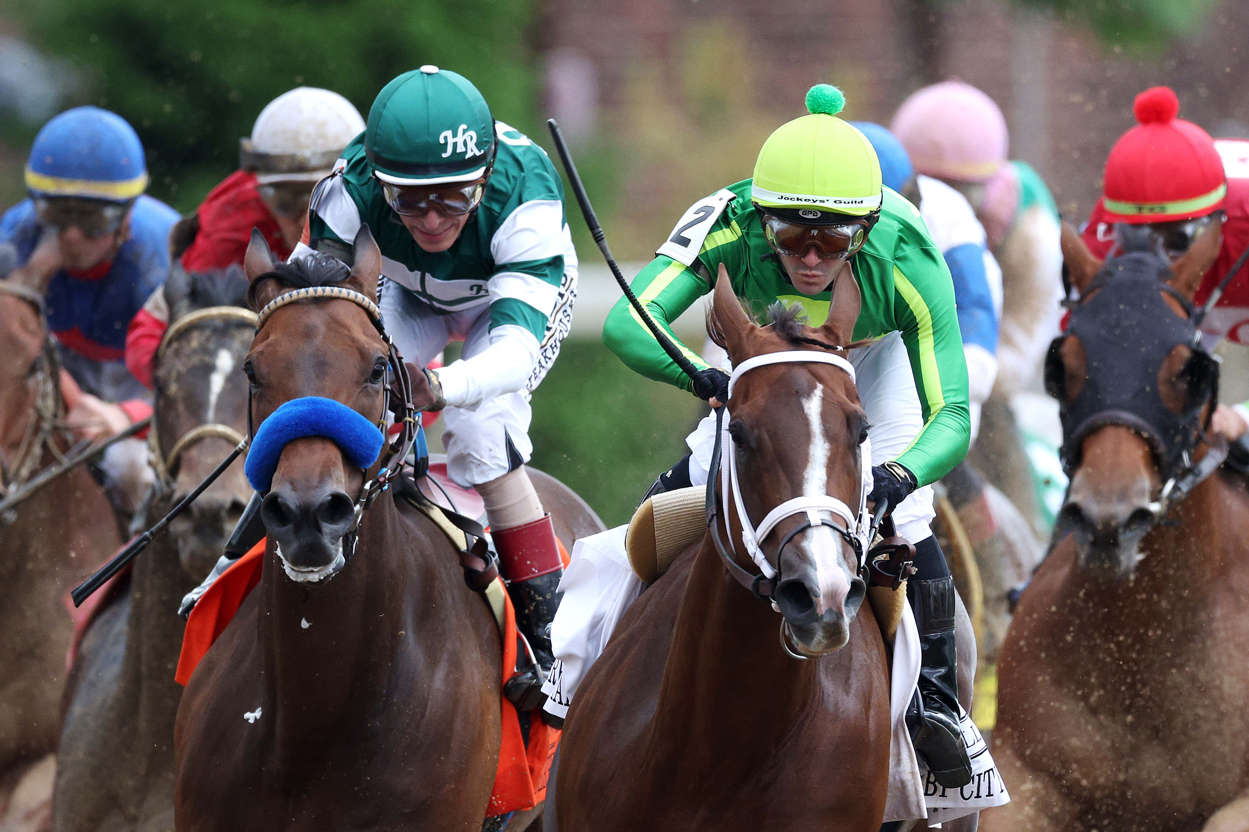 Kentucky Derby 桌布 壁紙 — 騎師身穿色彩繽紛的絲綢，身體前傾，馬匹在緊張刺激的賽馬中並駕齊驅。