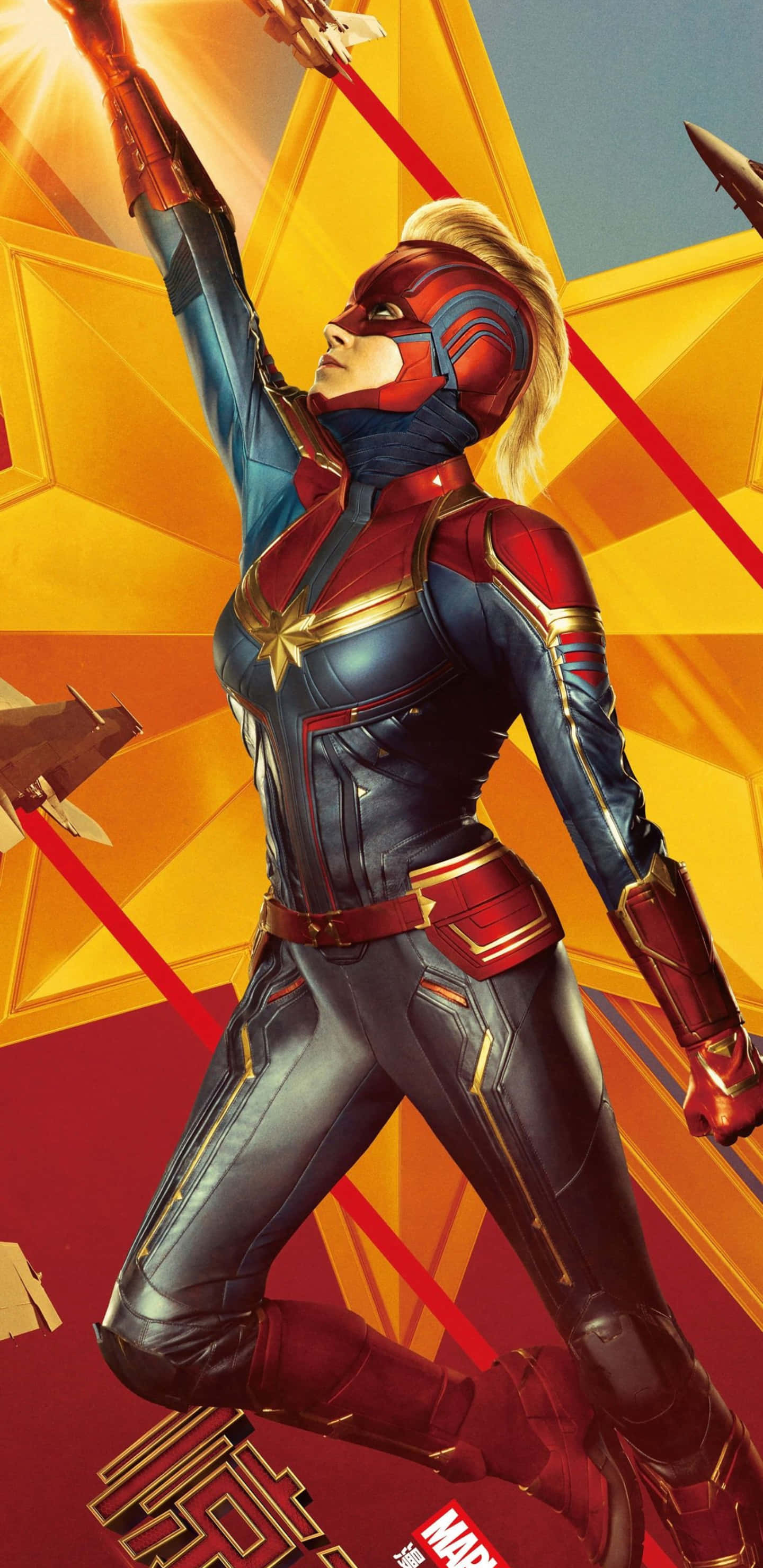 Pixel 3xl Captain Marvel 桌布 壁紙 — 驚奇隊長以動感姿態英勇地站立，背景是閃耀的金色星空，紅色能量光束劃破天際。