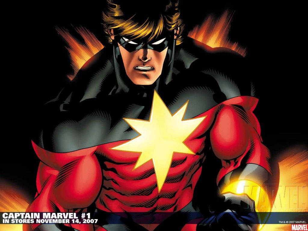 Captain Marvel 桌布 壁紙 — 驚奇隊長以動感漫畫姿勢強力站立，胸前有發光星星標誌，背景為熾熱黑色。
