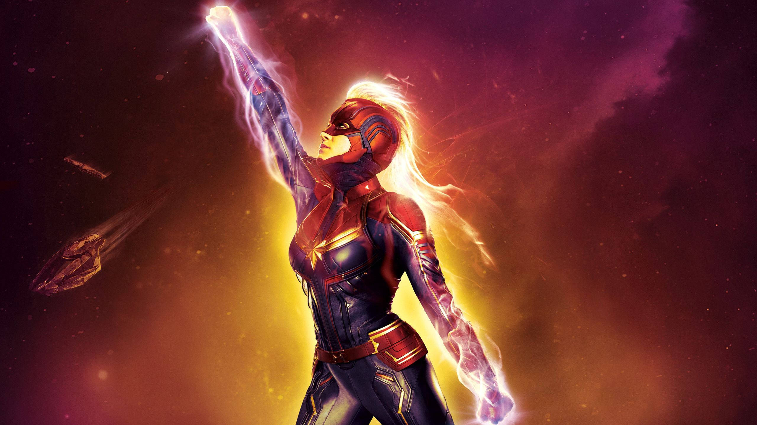 Captain Marvel Laptop 桌布 壁紙 — 驚奇隊長在太空中英勇站立，舉起的手散發出耀眼能量，背景是充滿活力的宇宙。