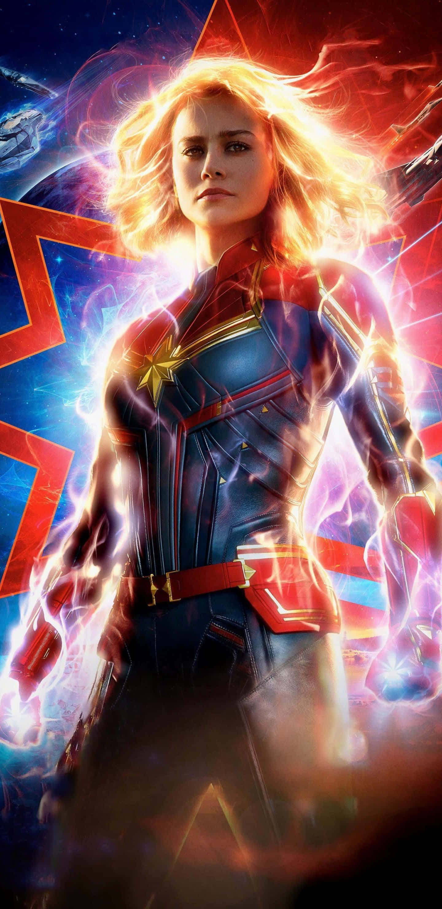 Pixel 3xl Captain Marvel 桌布 壁紙 — 驚奇隊長在宇宙風暴中強勢站立，閃爍的能量在她星形標誌的戰衣周圍噼啪作響。