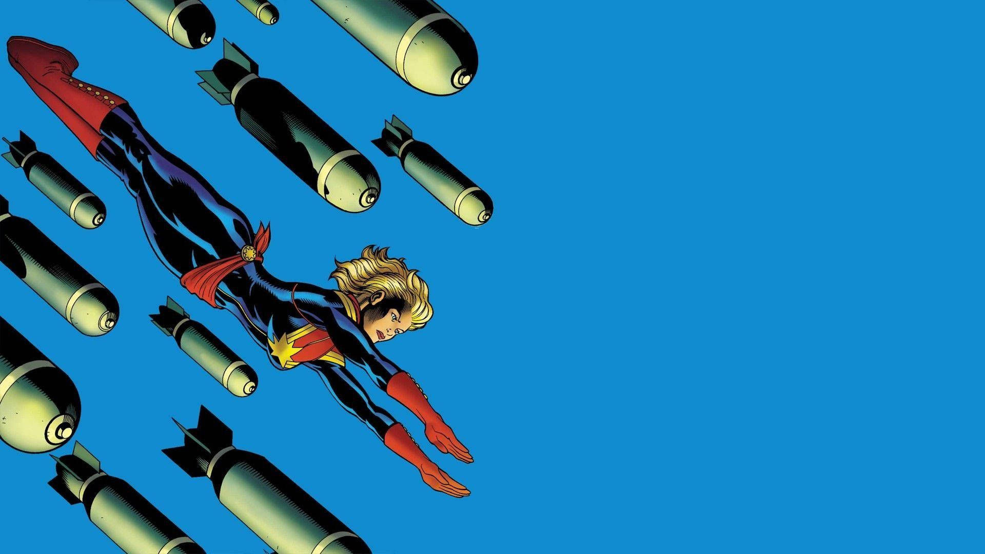 Captain Marvel 桌布 壁紙 — 驚奇隊長在晴朗的藍天中翱翔，躲避墜落的炸彈，呈現動態漫畫動作場景。