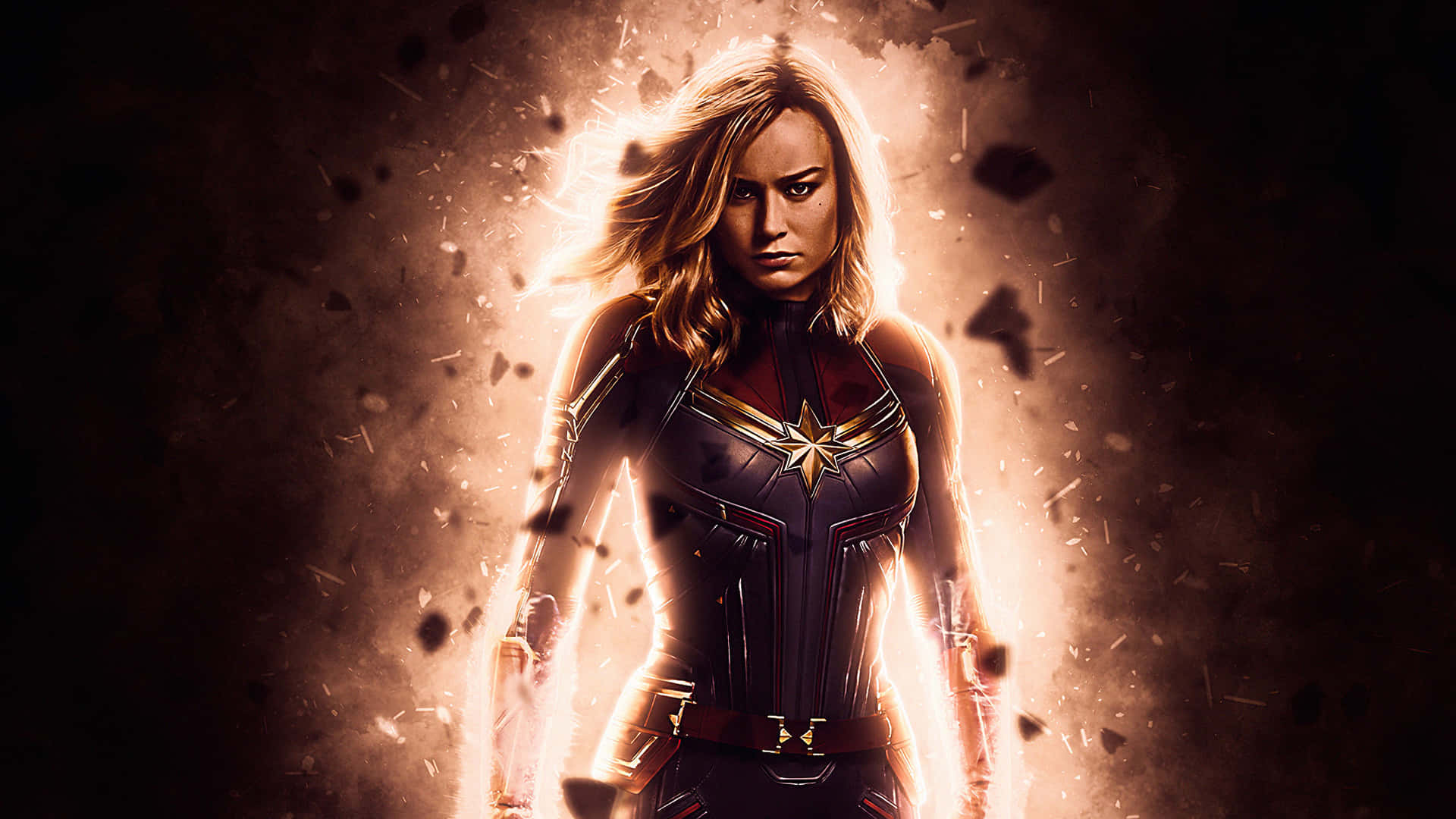 Captain Marvel HD 桌布 壁紙 — 驚奇隊長在金色光芒爆發中挑釁地站立，碎片在她周圍飛舞，呈現出戲劇性的電影姿勢。