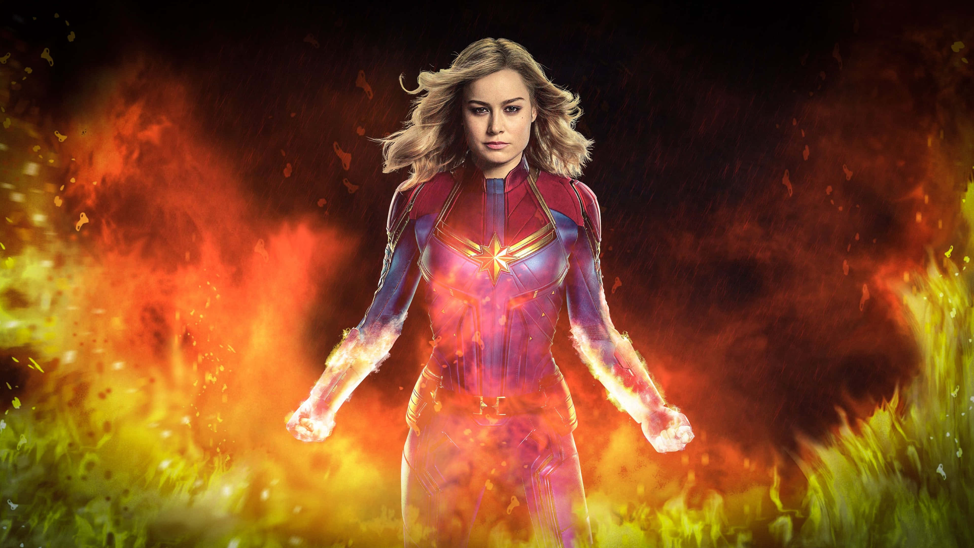 4K Marvel 壁紙 桌布 壁紙 — 驚奇隊長強而有力地站在旋轉的火焰能量中，拳頭發光，表情堅定。