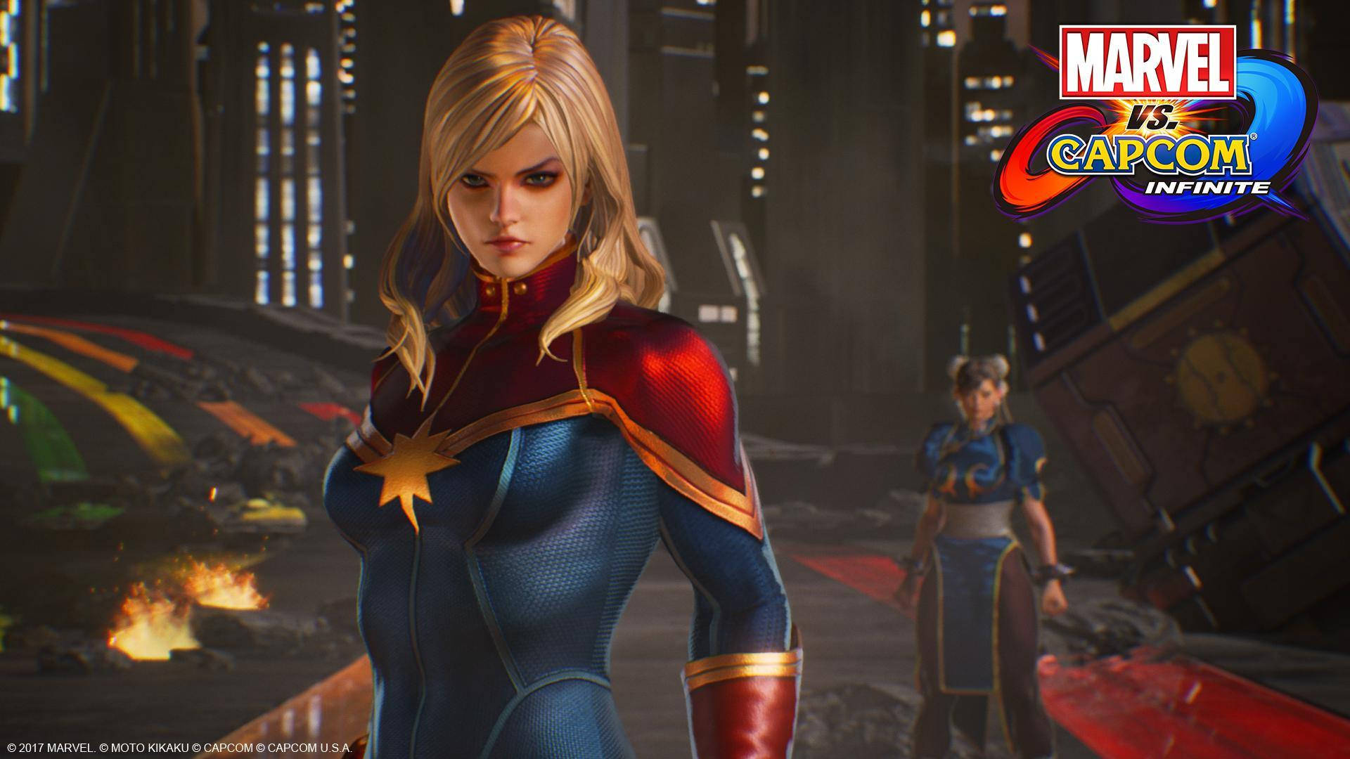 Captain Marvel 桌布 壁紙 — 驚奇隊長自信地站在一個未來風格的競技場中，背景有燃燒的碎片和一個遙遠的對手。