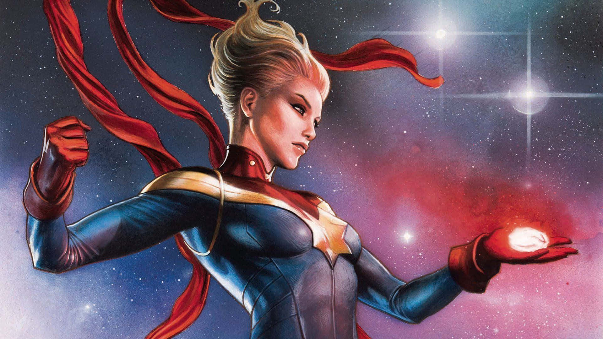 Captain Marvel 桌布 壁紙 — 驚奇隊長英勇地站在太空中，手中握著發光的能量，紅色斗篷飄揚，背景是繁星點點的宇宙。