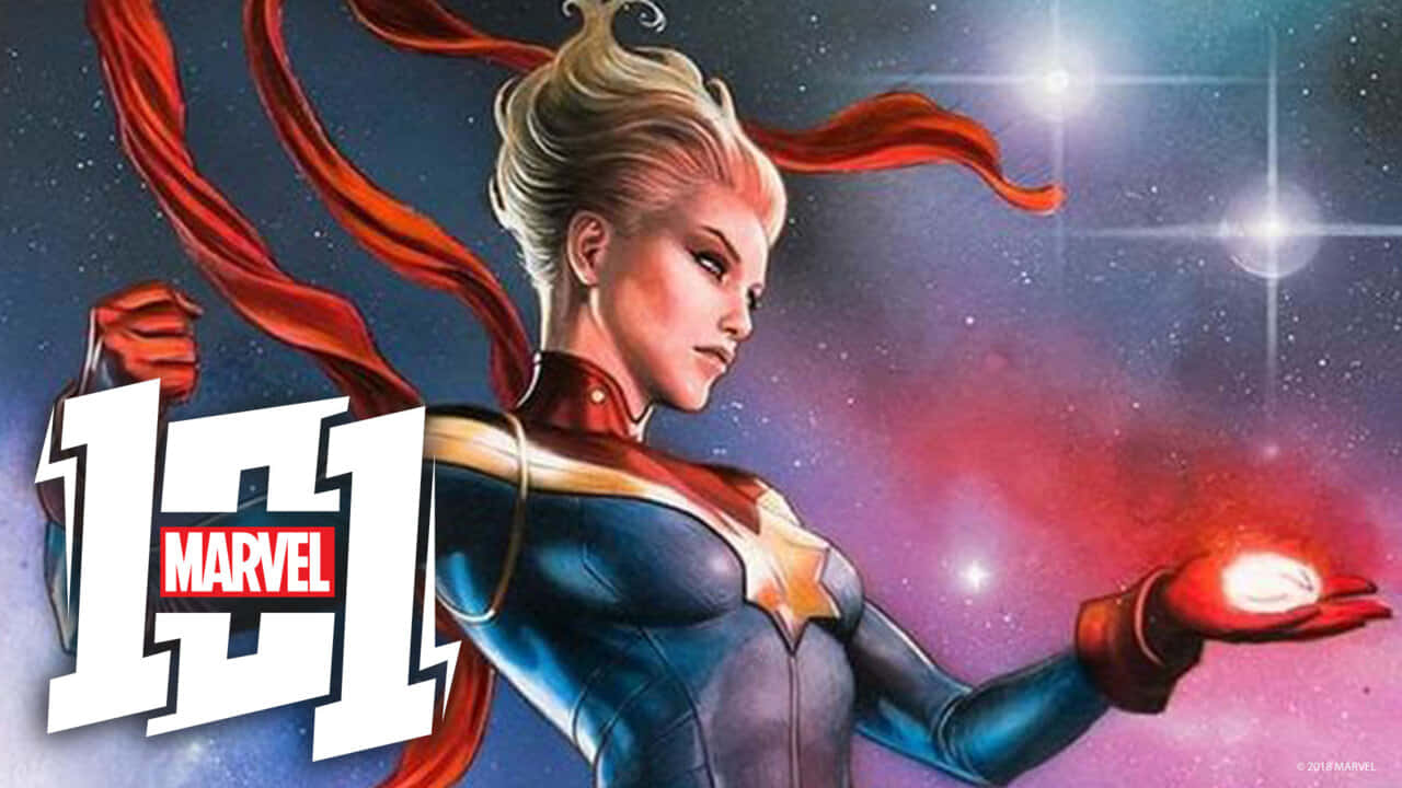 Marvel Profile 桌布 壁紙 — 驚奇隊長英勇地站在太空中，手持發光球體，紅色斗篷在繁星宇宙背景下飄揚。