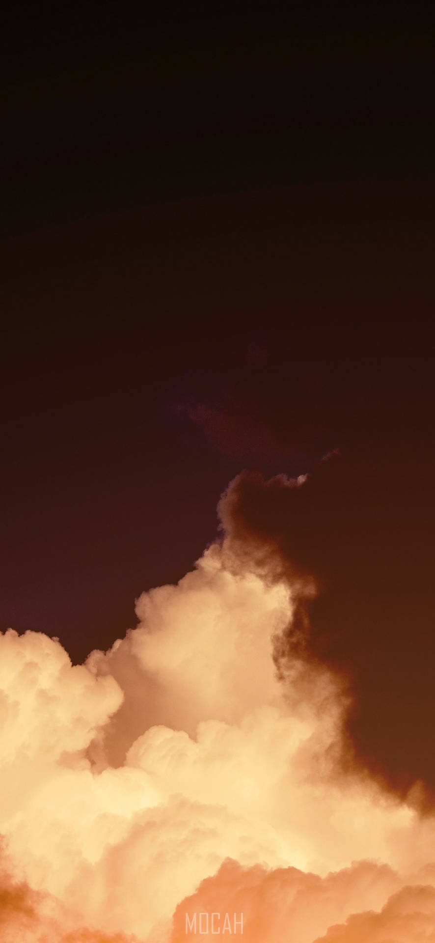 戲劇性的雲朵在黑暗的暮色天空中閃耀著橙色。