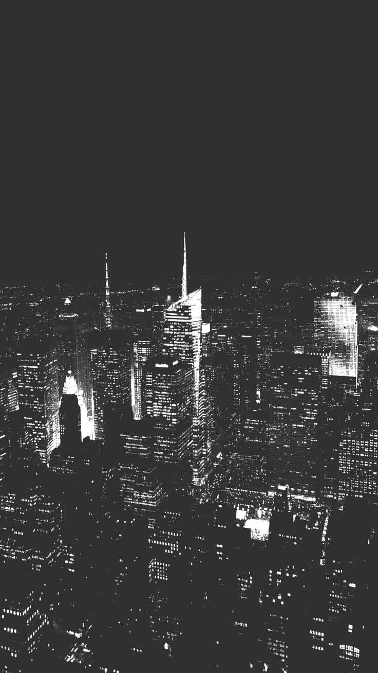 美學 桌布 壁紙 — 高對比度黑白航拍夜景，密集城市天際線，窗戶在黑暗天空中發光。