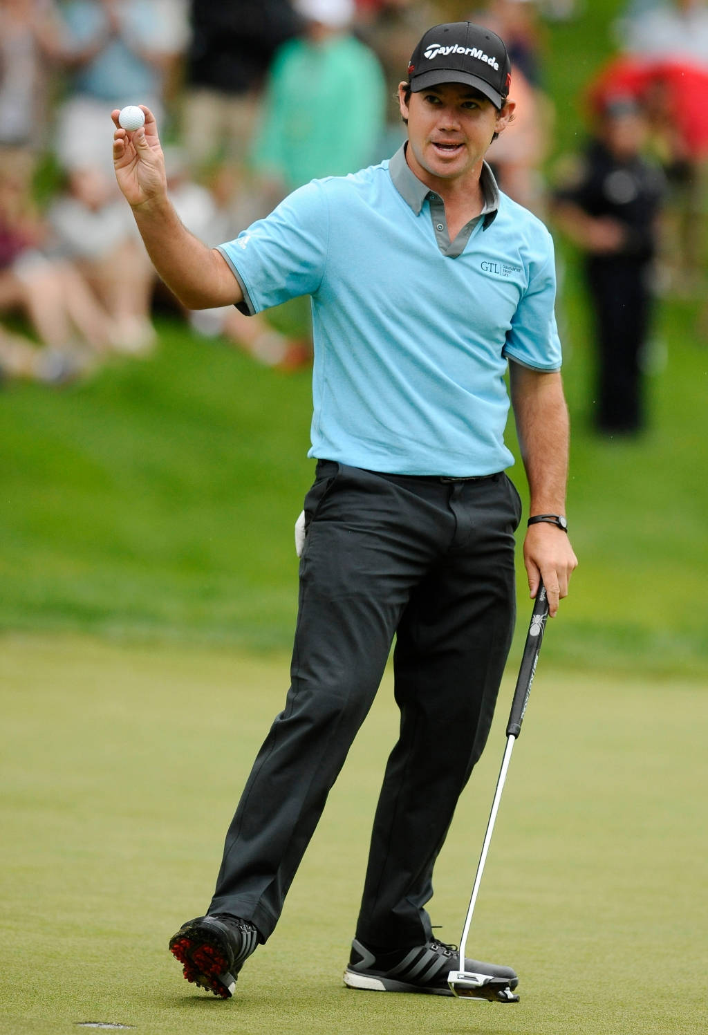 高爾夫 桌布 壁紙 — 高爾夫球手Rory McIlroy在翠綠的高爾夫球場上慶祝，手持高爾夫球和推桿。