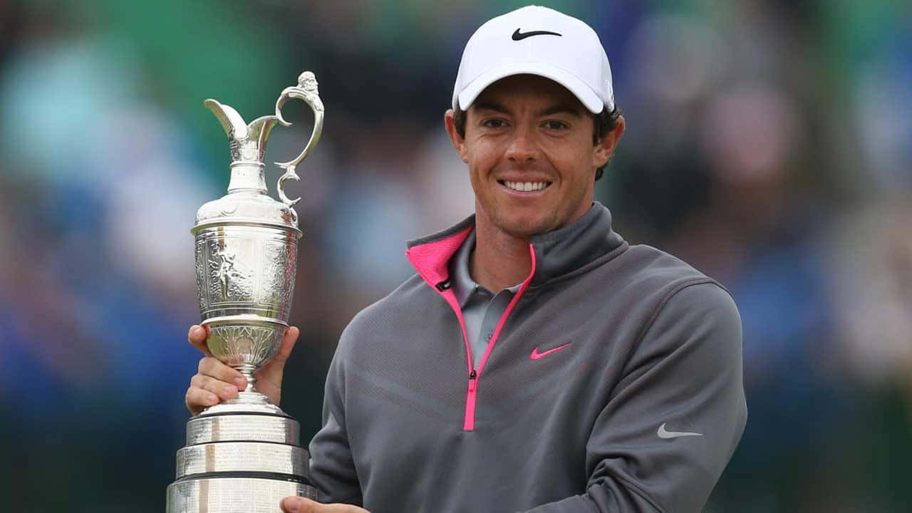 高爾夫 桌布 壁紙 — 高爾夫球手Rory McIlroy在高爾夫錦標賽中自豪地微笑，手持標誌性的銀色Claret Jug獎盃。