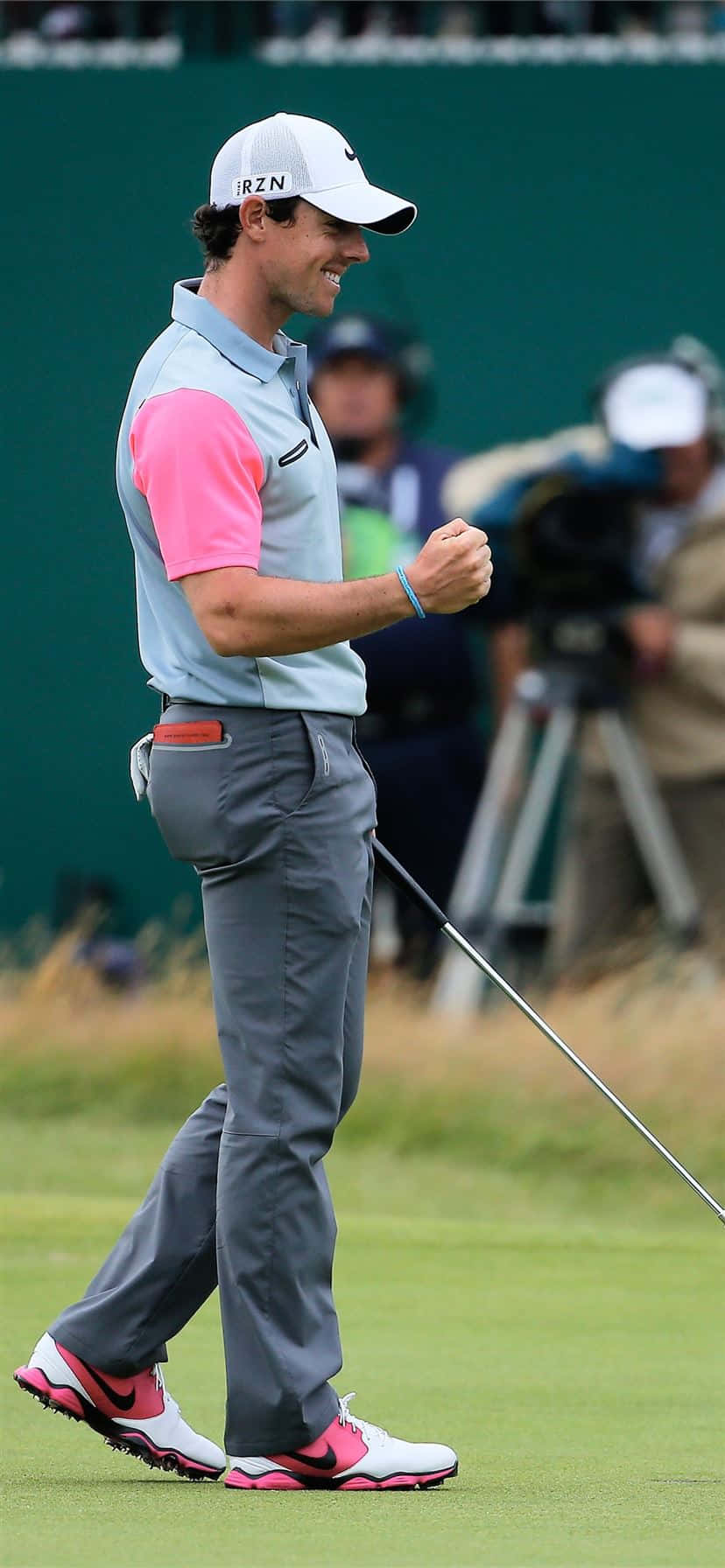 fist pump 桌布 壁紙 — 高爾夫球手Rory McIlroy在綠色高爾夫球場上穿著粉紅色和灰色裝備，以拳擊慶祝。