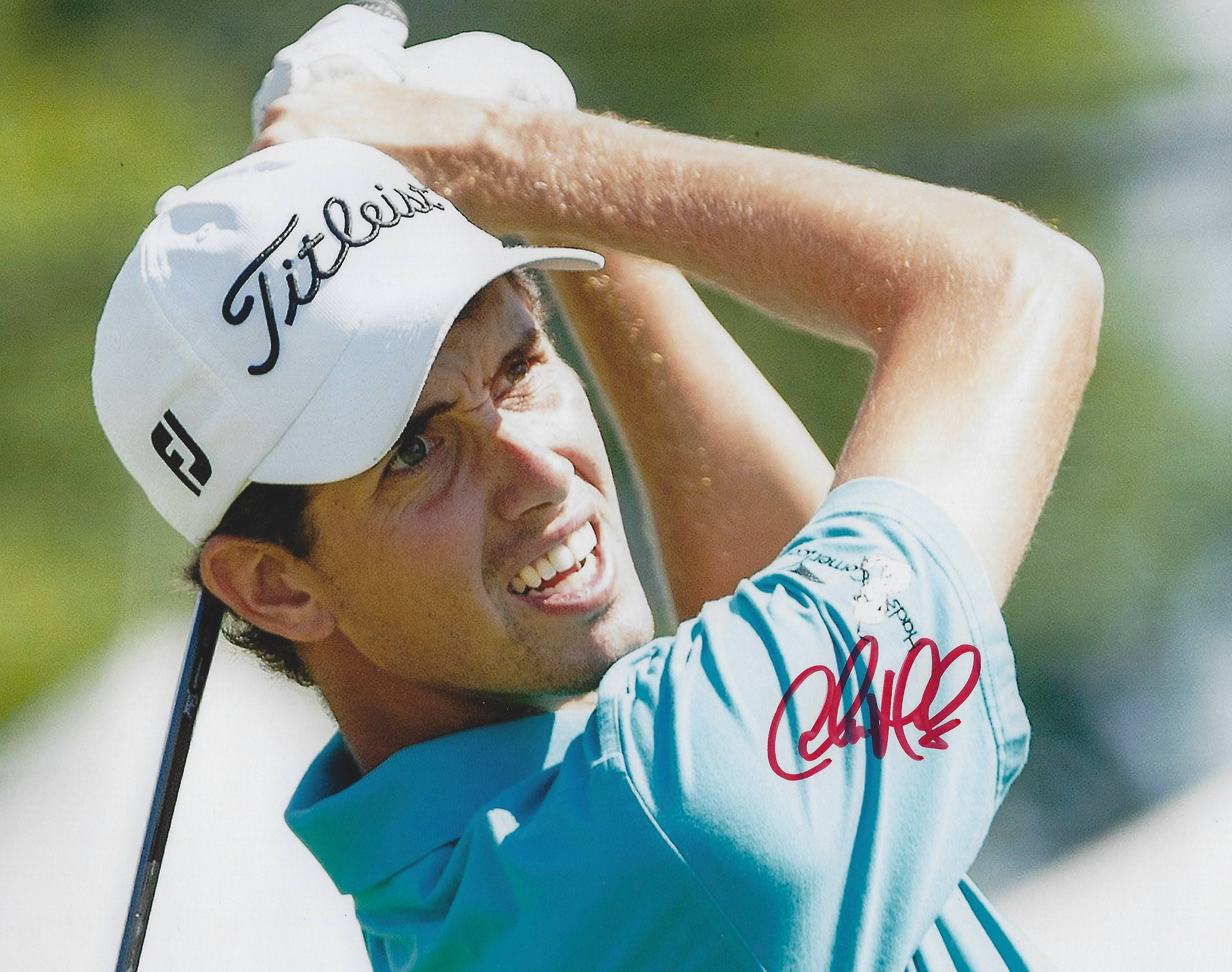 高爾夫 桌布 壁紙 — 高爾夫球手Rory McIlroy揮桿中，戴白色Titleist帽，穿藍色衫，袖上有紅色簽名。