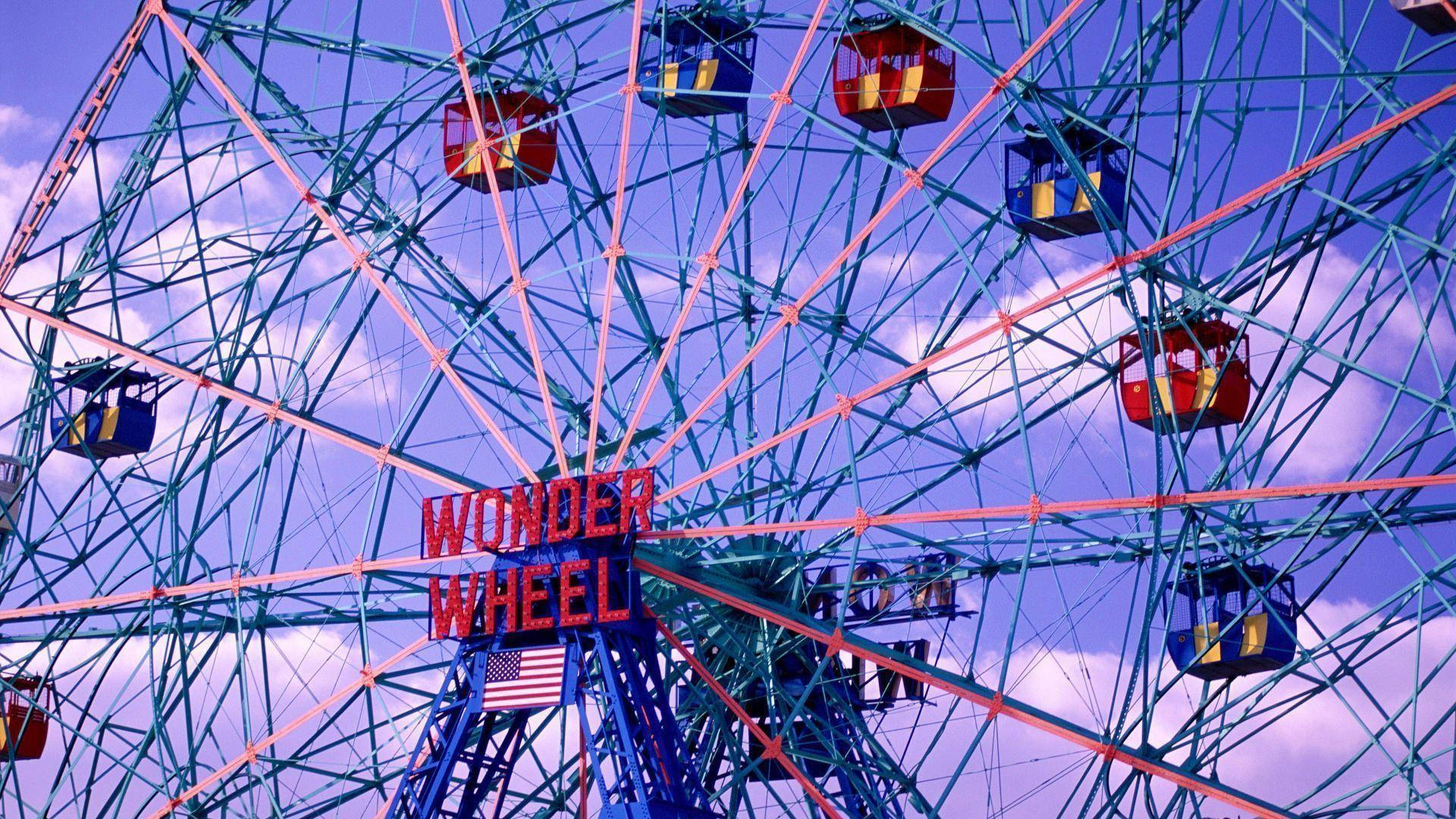 美學 桌布 壁紙 — 高聳的 Wonder Wheel 遊樂園遊樂設施，色彩繽紛的纜車映襯著暮色天空。