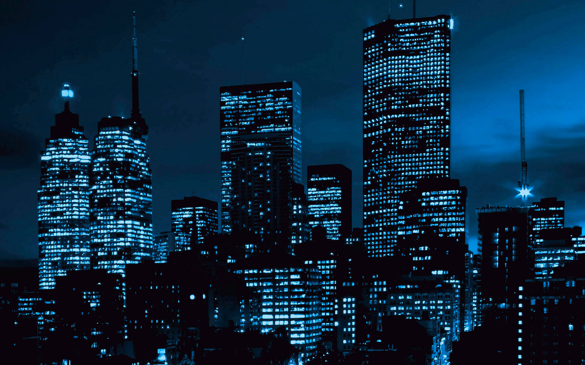 New Jersey 桌布 壁紙 — 高聳的城市天際線在夜晚沐浴在無數窗戶散發的冷藍光中，映襯著黑暗的天空。