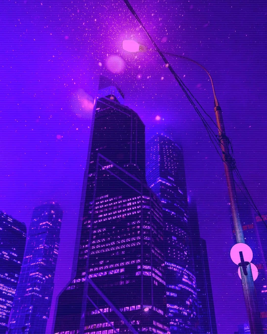 夜空 桌布 壁紙 — 高聳的摩天大樓在充滿活力的紫色夜空下發光，伴隨著漂浮的粒子和霓虹街燈。