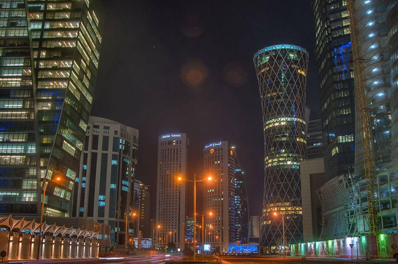 夜空 桌布 壁紙 — 高聳的摩天大樓在繁華的現代城市景觀中，以冷暖色調的光芒映照著漆黑的夜空。