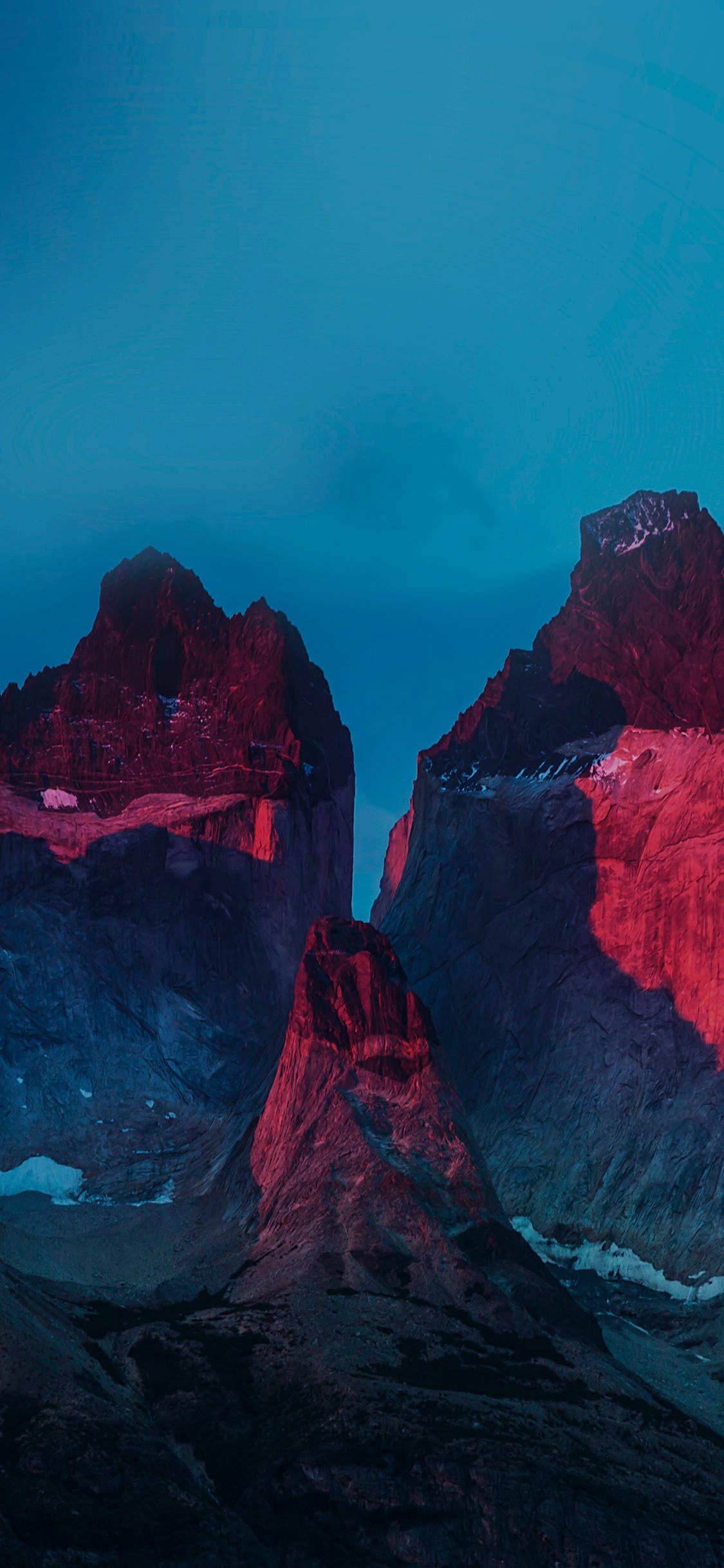 Yosemite iPhone 桌布 壁紙 — 高聳的鋸齒狀山脈在深藍色的暮色天空中散發出火紅的光芒。