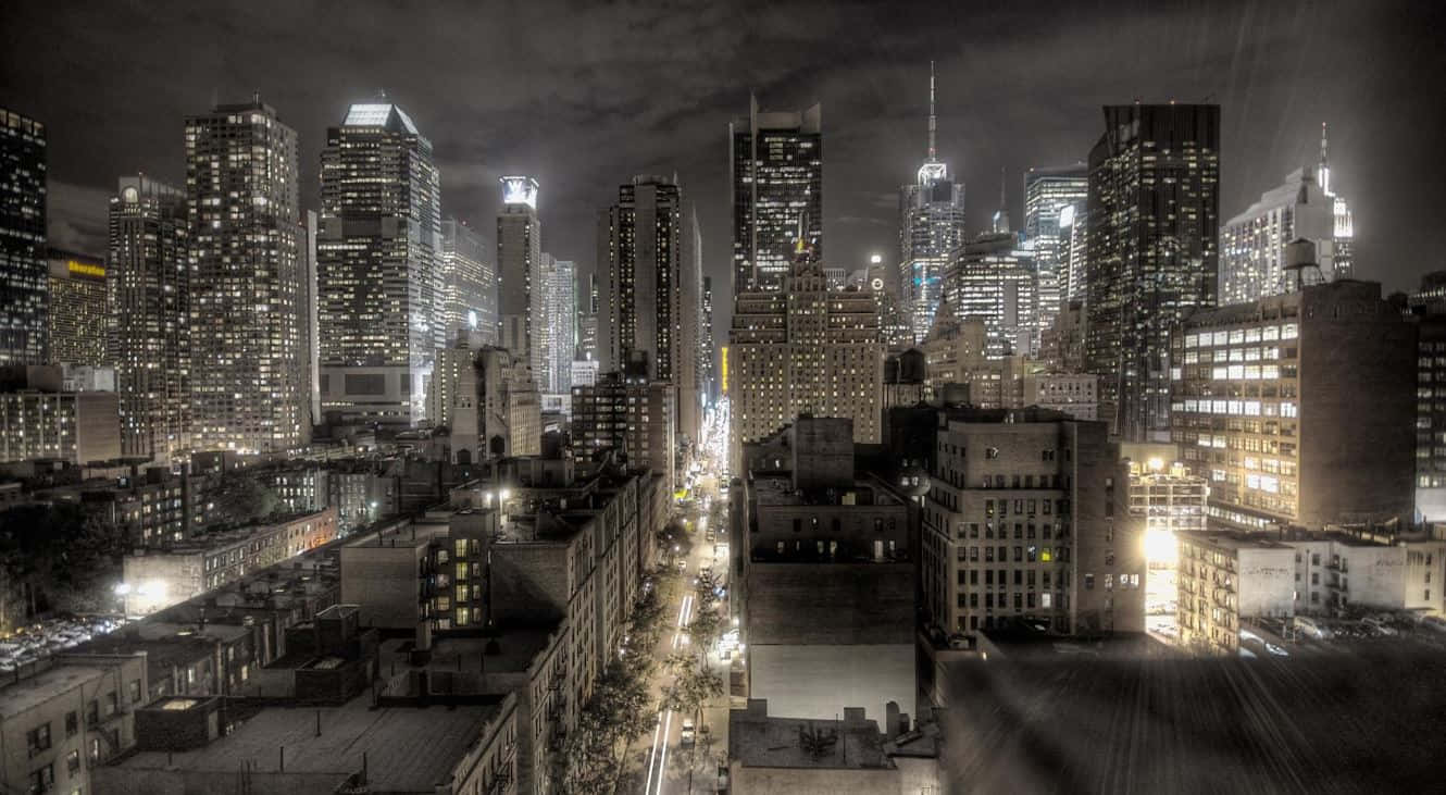 Gotham City 桌布 壁紙 — 高角度夜景，俯瞰密集的城市天際線，下方有燈火通明的摩天大樓和發光的街燈。