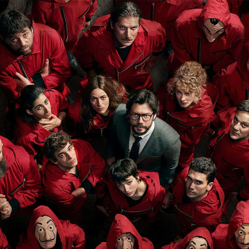 Money Heist Mask 桌布 壁紙 — 高角度拍攝一群身穿紅色連身衣褲的人圍繞著一名穿西裝的男子，部分人戴著達利面具。