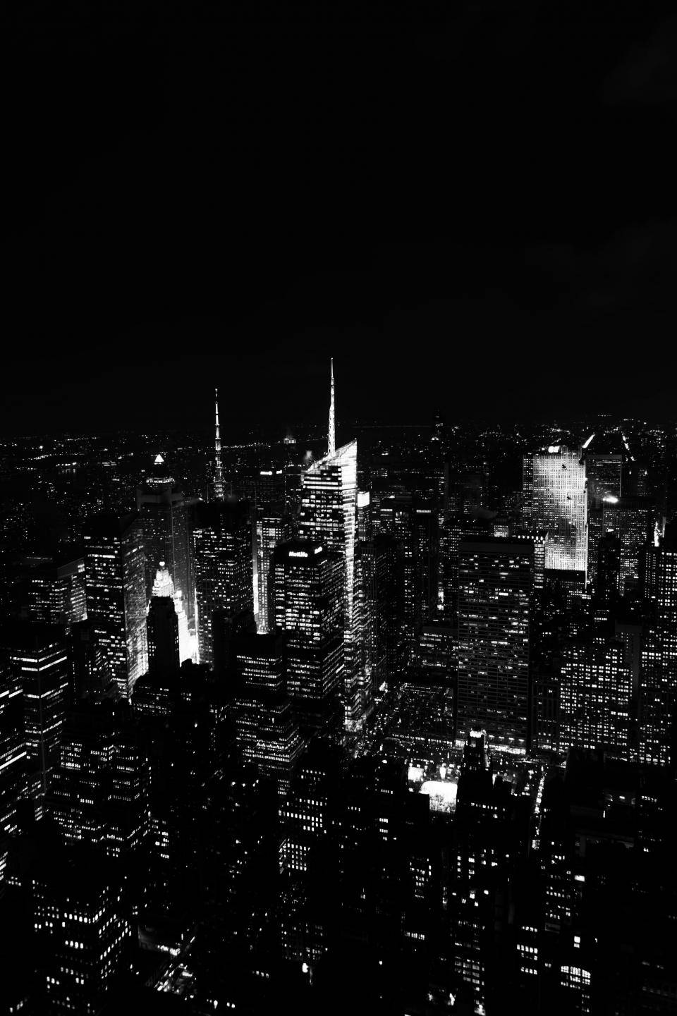New 桌布 壁紙 — 高角度拍攝的黑白夜景，密集的城市天際線中，發光的窗戶刺破黑暗。