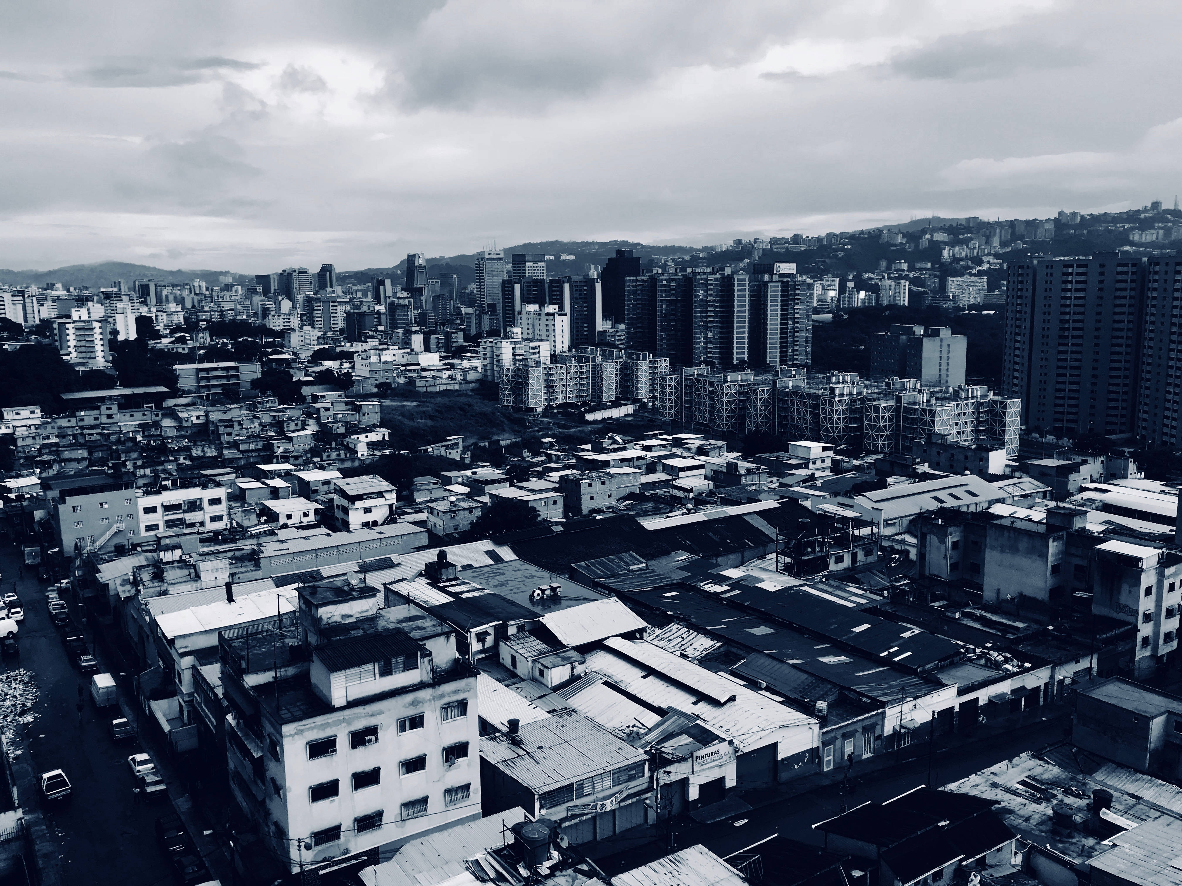 Venezuela 桌布 壁紙 — 高角度黑白視角，俯瞰密集的城市擴展區，混合建築風格，天空多雲。