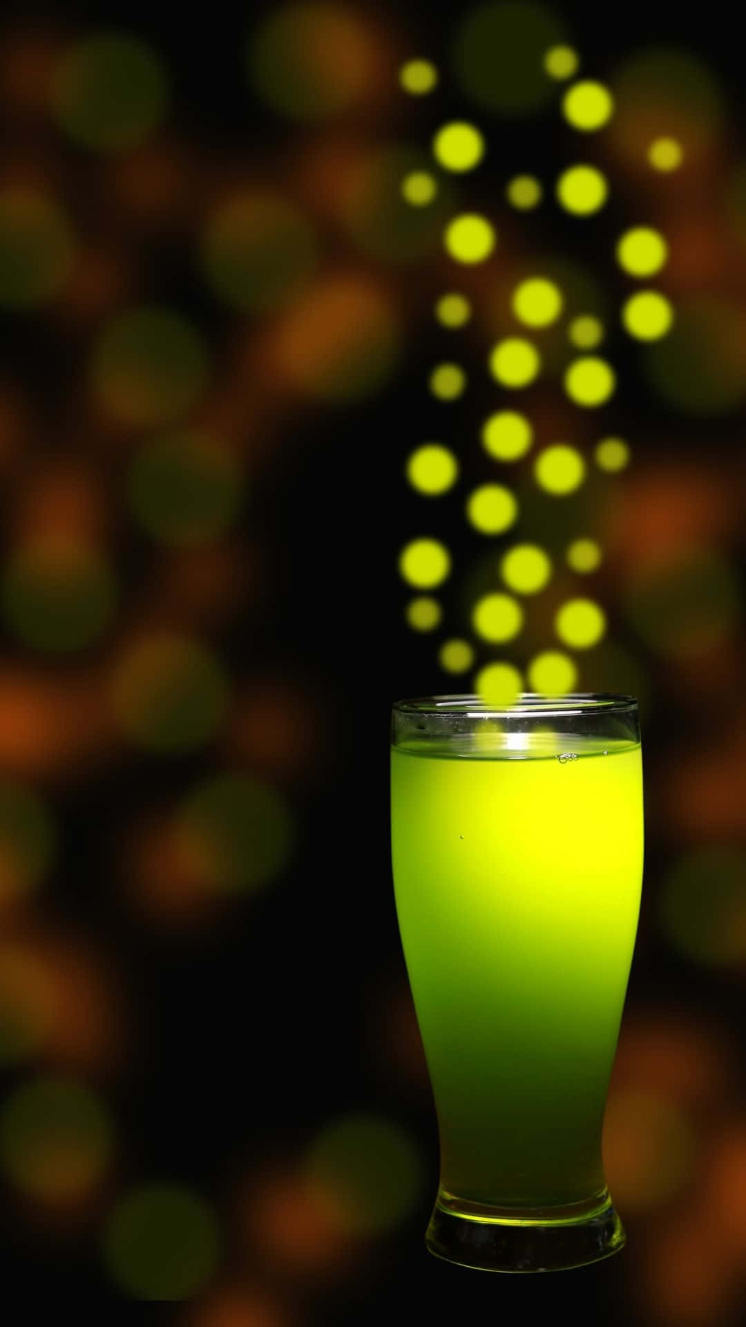 Glow In The Dark 桌布 壁紙 — 高身玻璃杯中的發光綠色飲品，背景有散景燈光。