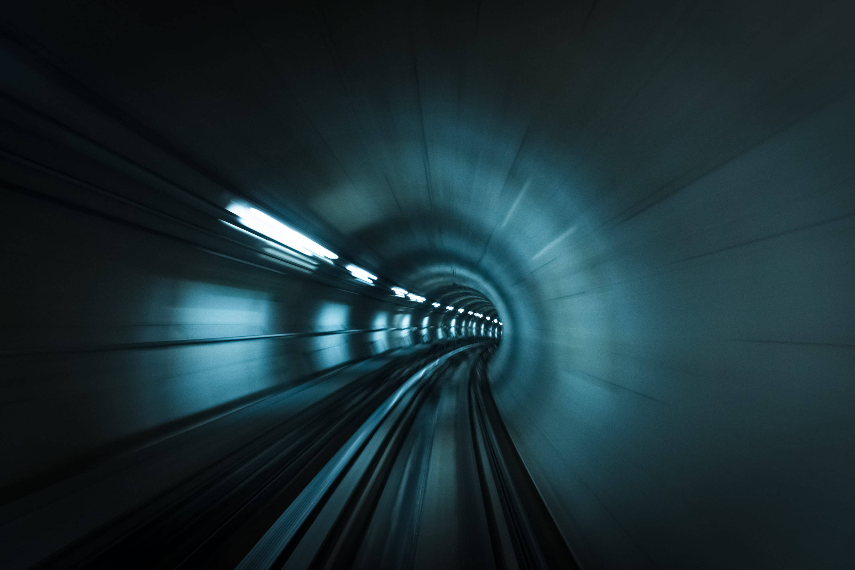 Subway 桌布 壁紙 — 高速動態模糊拍攝穿過深藍色燈光隧道，光線條紋向遠方延伸。