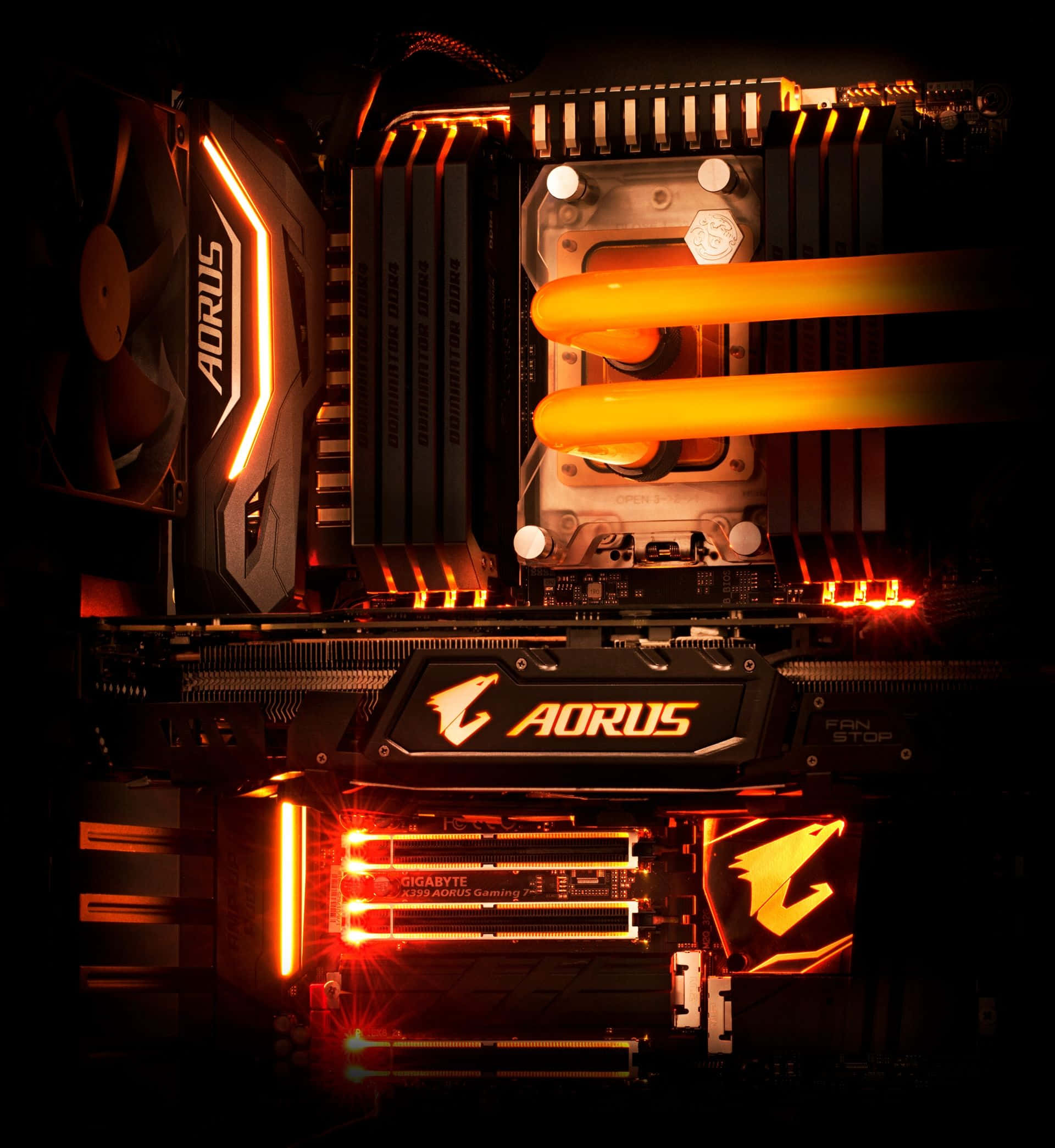 4K Graphics Cards 桌布 壁紙 — 高階AORUS遊戲主機板特寫，帶有發光的橙色RGB燈光和液體冷卻管道，背景為深色。
