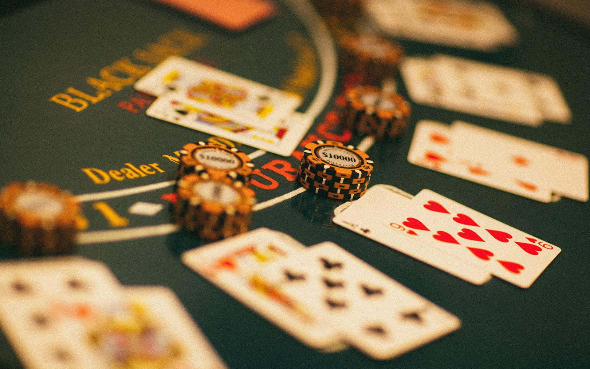 撲克牌桌 桌布 壁紙 — 高風險二十一點賭桌特寫，有$10000籌碼和面朝上的撲克牌在綠色絨布上。
