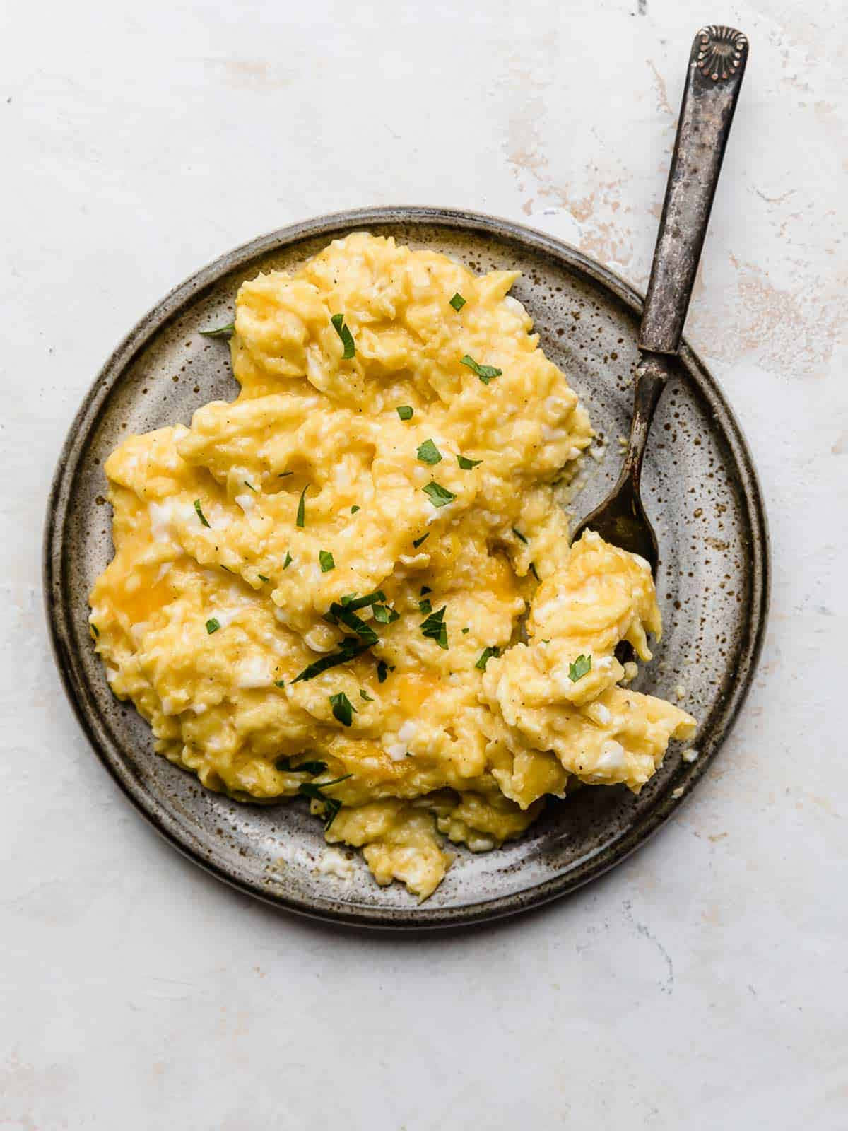 Scrambled Egg 桌布 壁紙 — 鬆軟炒蛋配上新鮮歐芹，放在鄉村風格斑點盤上，旁邊配有一把復古湯匙。