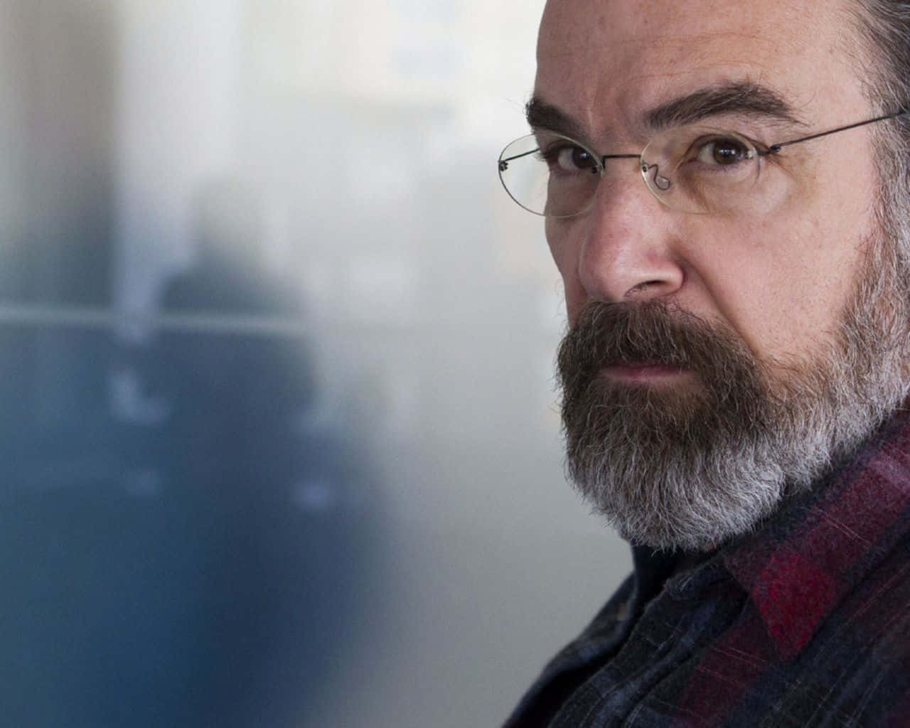 Mandy Patinkin 桌布 壁紙 — 鬍鬚男戴眼鏡的特寫肖像，專注地看著鏡頭，背景模糊。