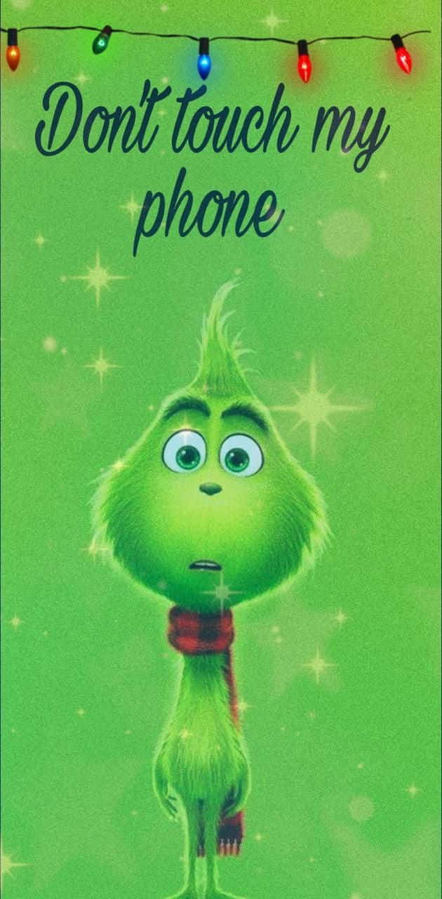 Cute Grinch 桌布 壁紙 — 鬼靈精睜大眼睛站在節日燈光下，背景是閃爍星星的發光綠色背景。