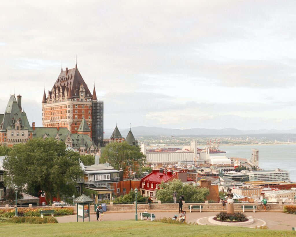 加拿大 桌布 壁紙 — 魁北克市的全景，Château Frontenac 在歷史建築和河流之上主導天際線，天空多雲。