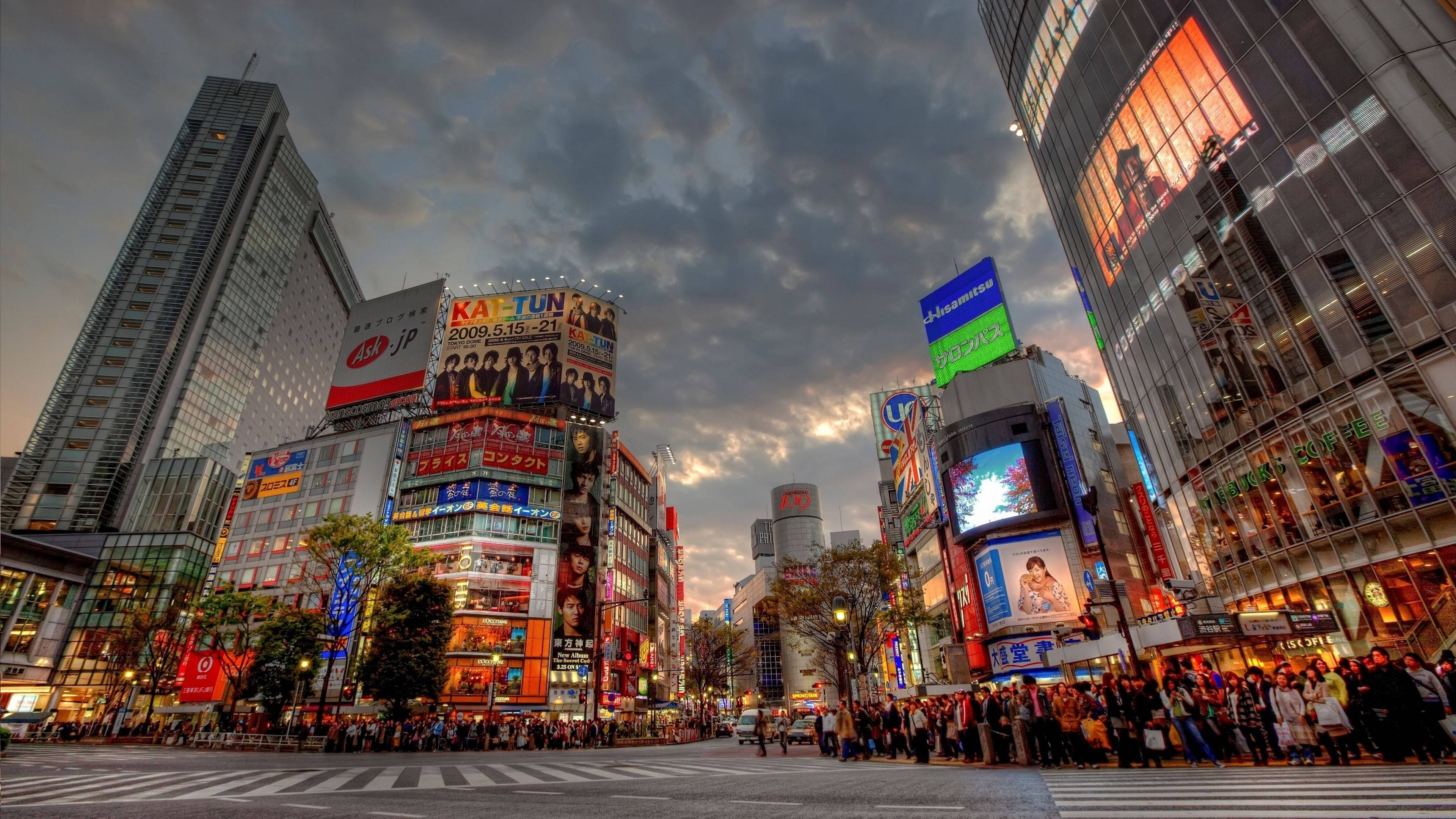 東京 桌布 壁紙 — 魚眼鏡頭下的東京繁華街道，黃昏時分，高聳建築在陰天天空下閃耀。