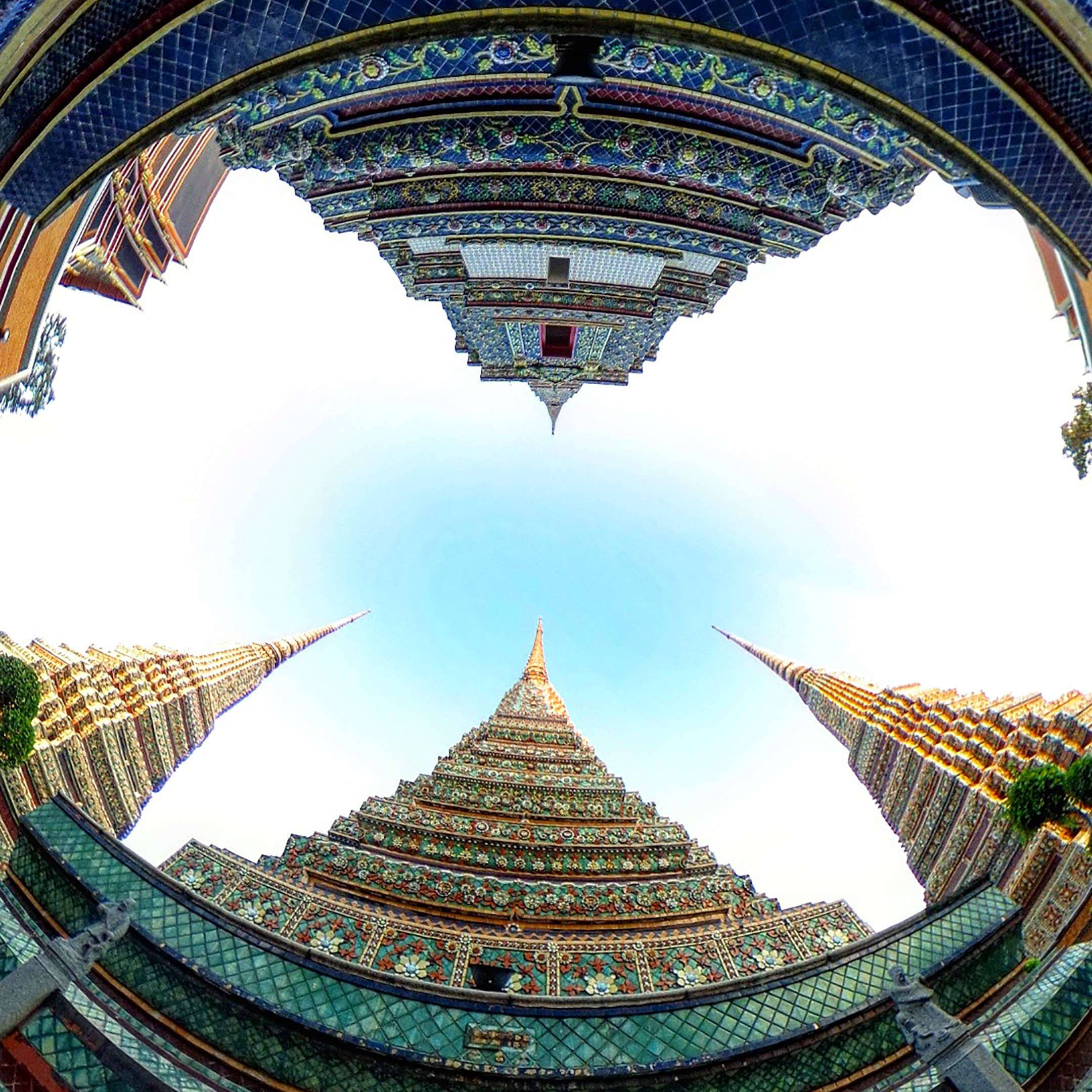 Bangkok 桌布 壁紙 — 魚眼鏡頭向上仰望華麗的金色和藍色瓷磚寺廟尖塔，襯著明亮的藍天。