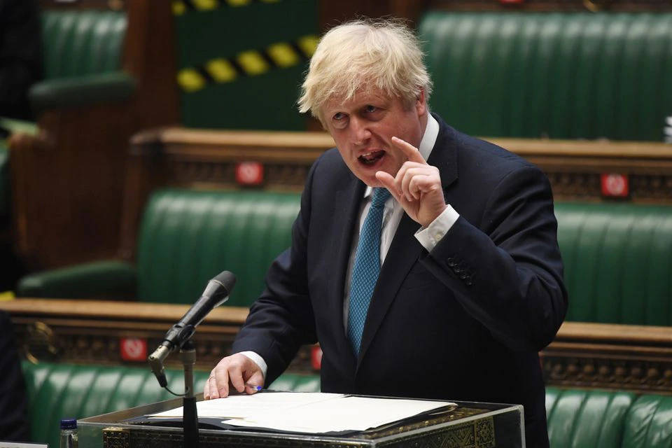 Boris Johnson 桌布 壁紙 — 鮑里斯·強森在綠色皮革襯裡的英國下議院講台上發言時，用力地做手勢。