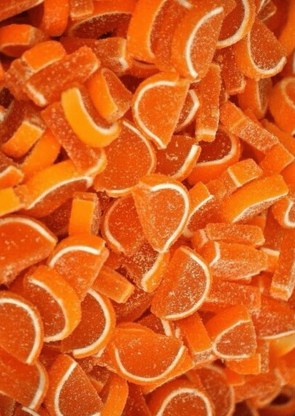 Sweets 桌布 壁紙 — 鮮橙色柑橘片形軟糖的特寫，邊緣有糖粒。