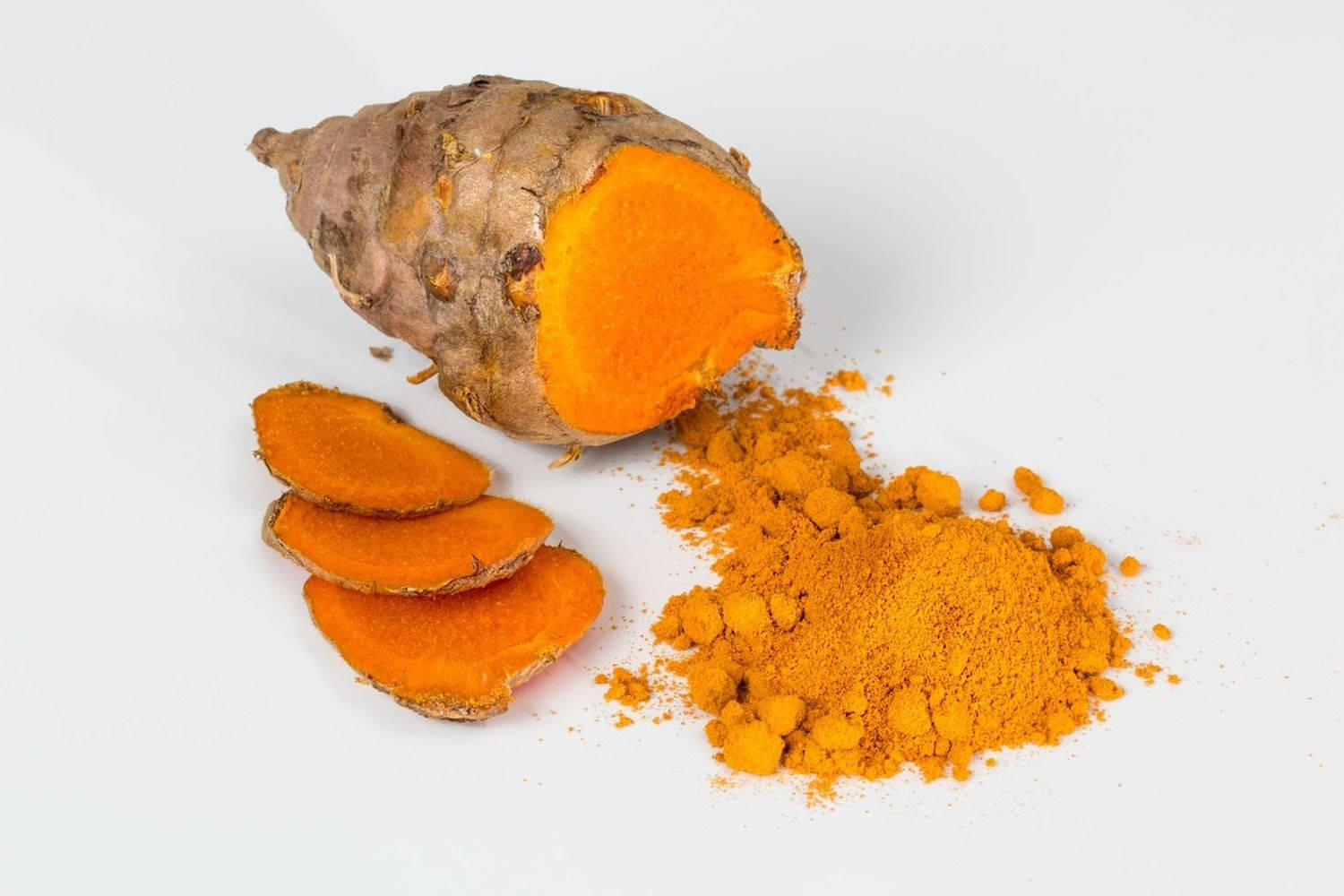 Spices 桌布 壁紙 — 鮮橙色的薑黃根切片並磨成粉末，置於潔白背景上。