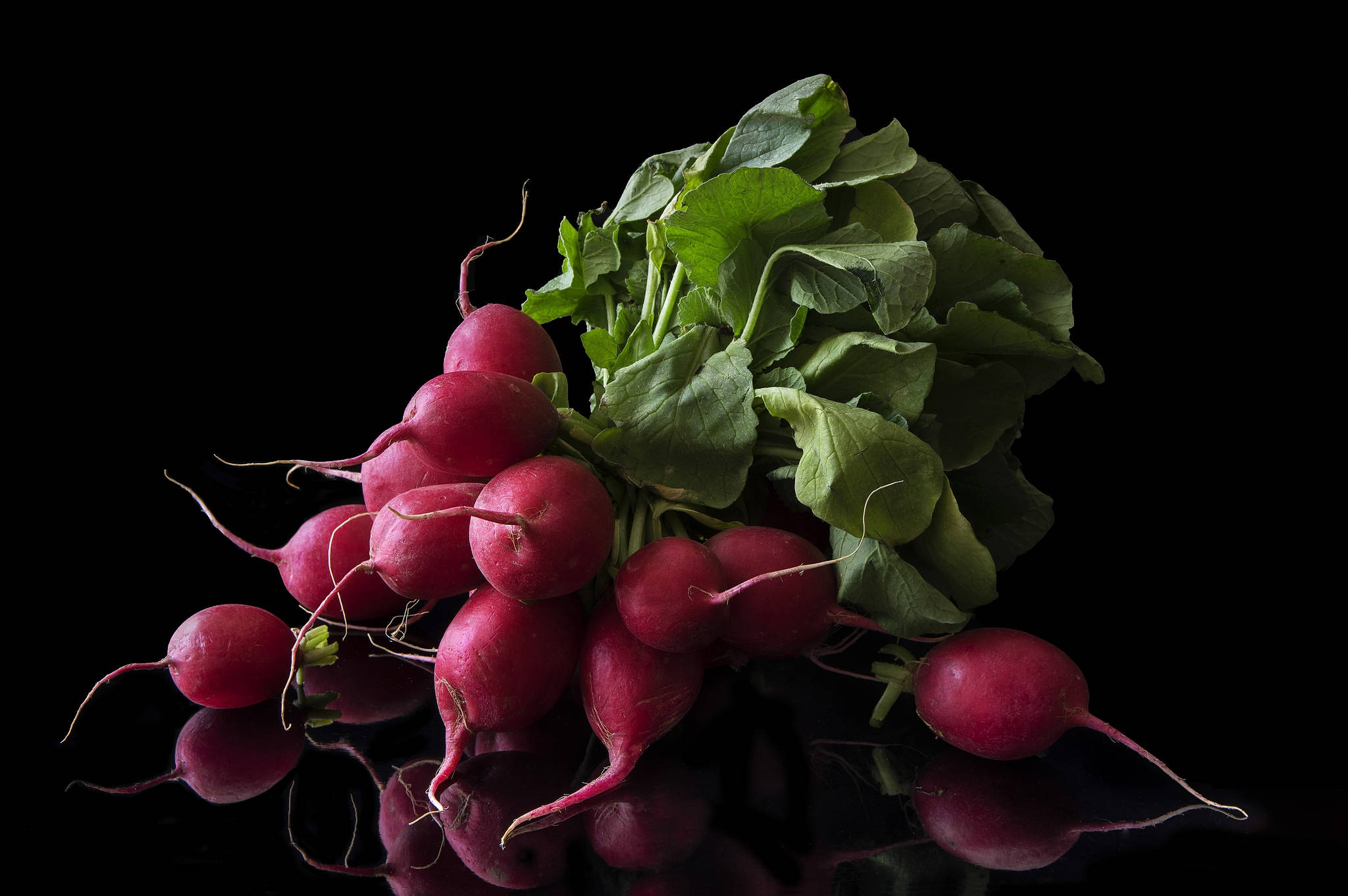 beetroot 桌布 壁紙 — 鮮紅的蘿蔔搭配茂盛的綠葉，排列在光亮的黑色表面上，反射出它們鮮豔的色彩。