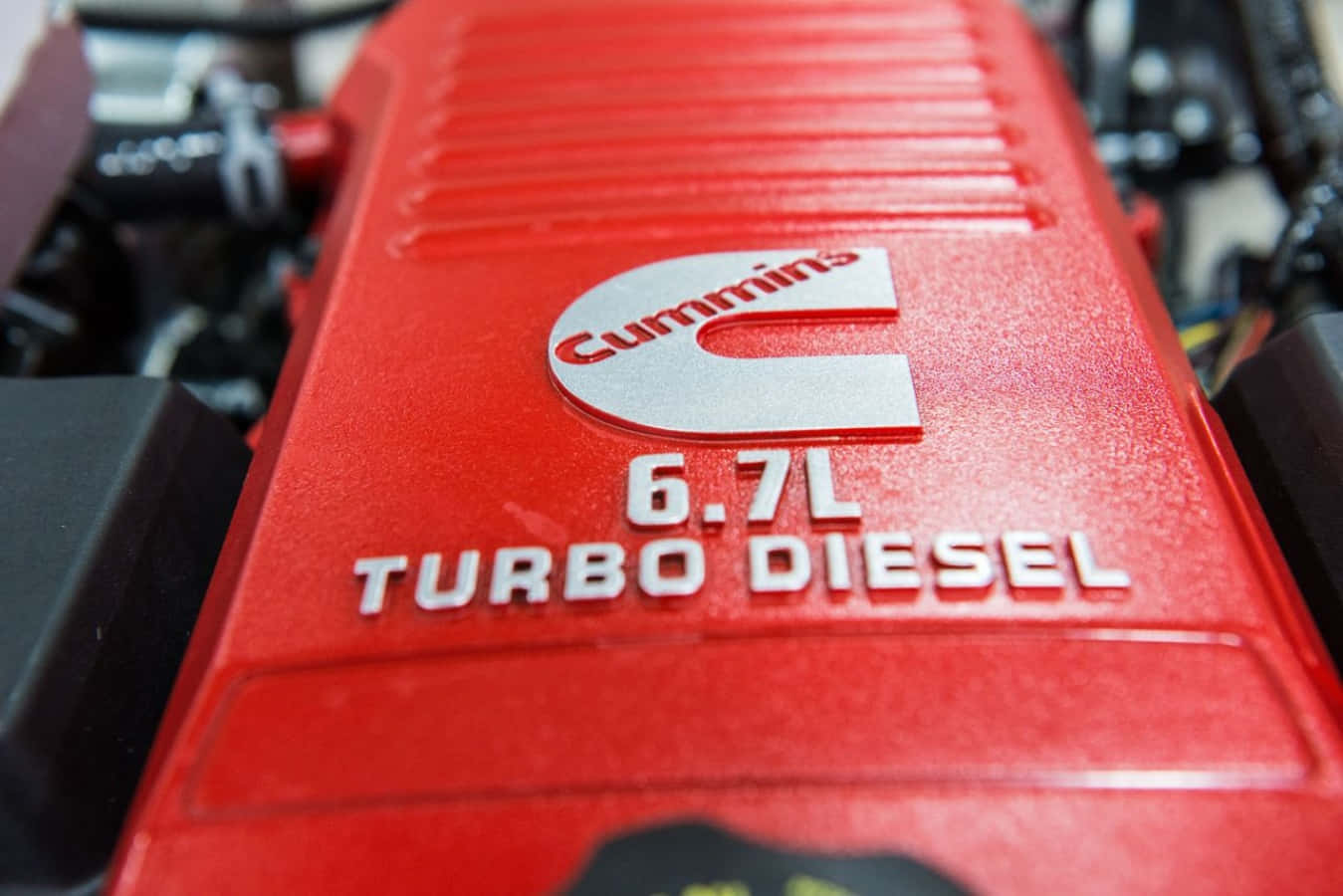 Diesel 桌布 壁紙 — 鮮紅色Cummins 6.7L Turbo Diesel引擎蓋特寫，帶有粗體白色字體和金屬標誌。