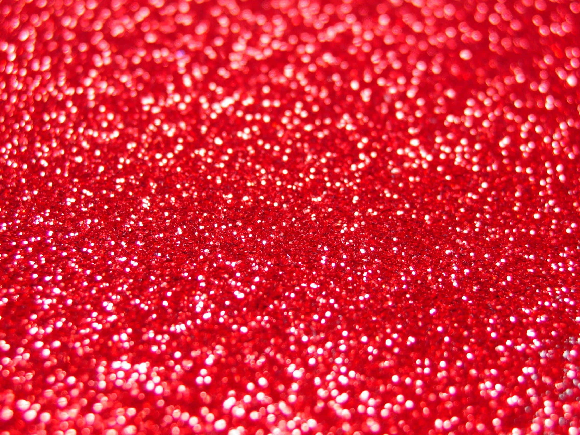 Red Glitter 桌布 壁紙 — 鮮紅色亮粉的特寫，閃爍的高光營造出有紋理的節日表面。