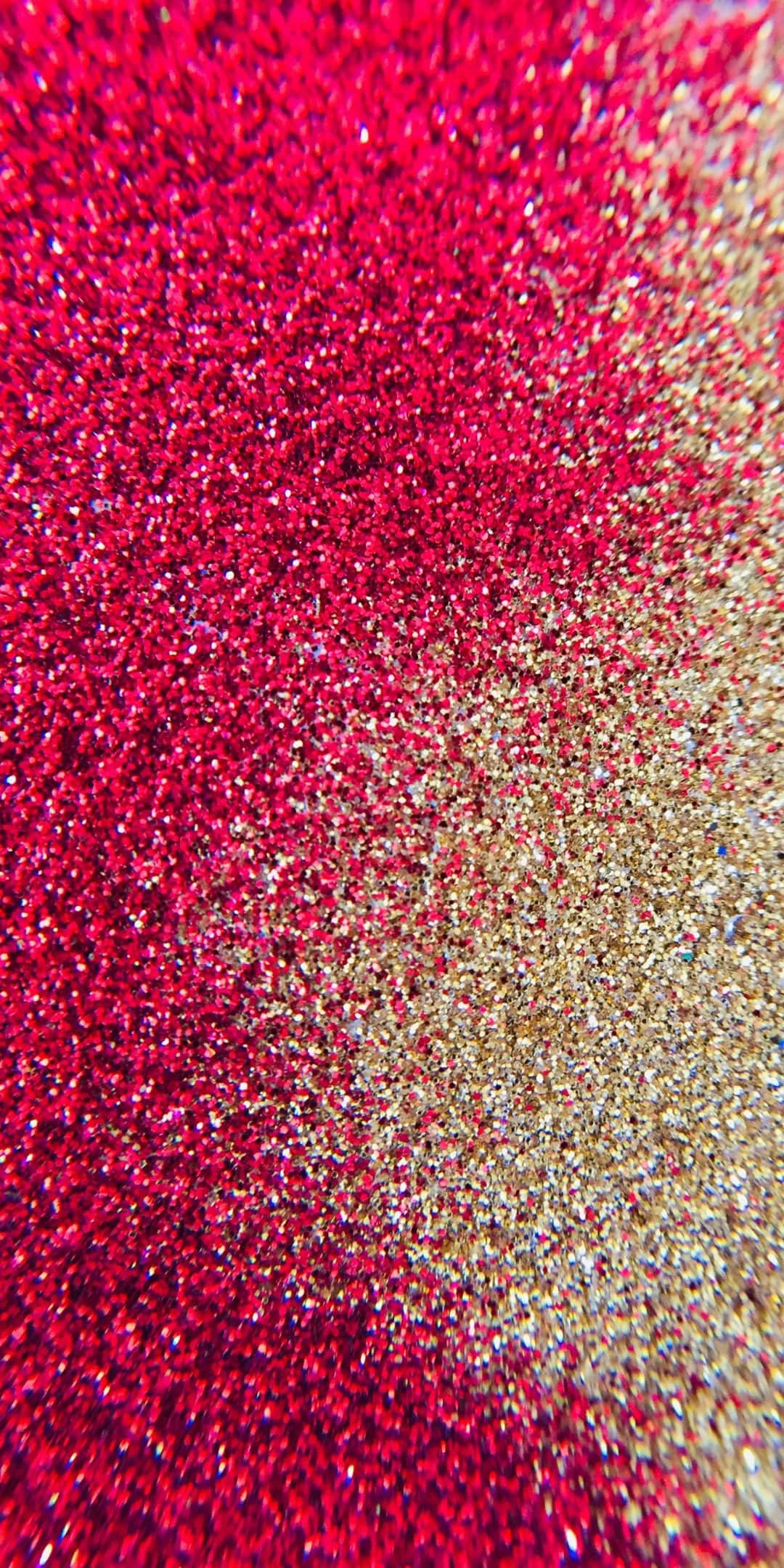 Pink And Gold 桌布 壁紙 — 鮮紅色和閃爍金色亮片混合成閃亮漸變紋理的近距離特寫。