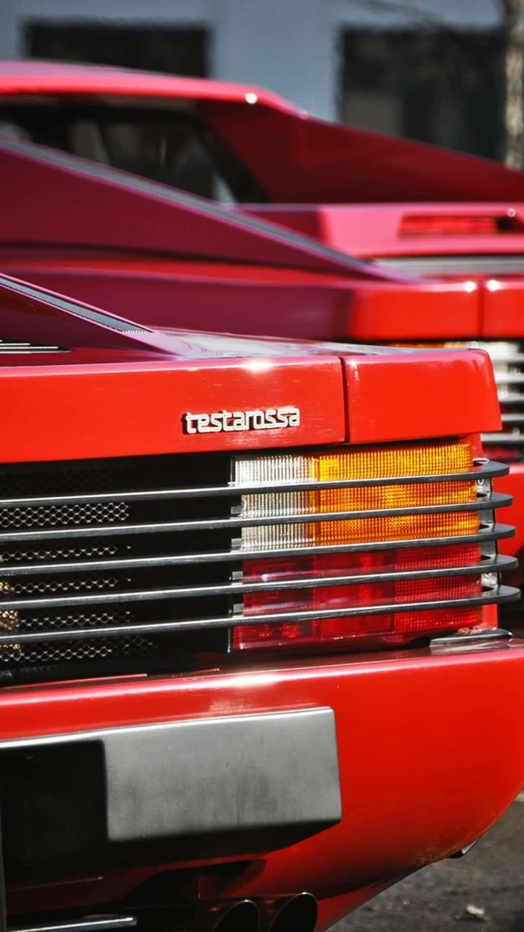 Ferrari Testarossa 桌布 壁紙 — 鮮紅色法拉利 Testarossa 車尾特寫，帶有鍍鉻飾條和發光尾燈。