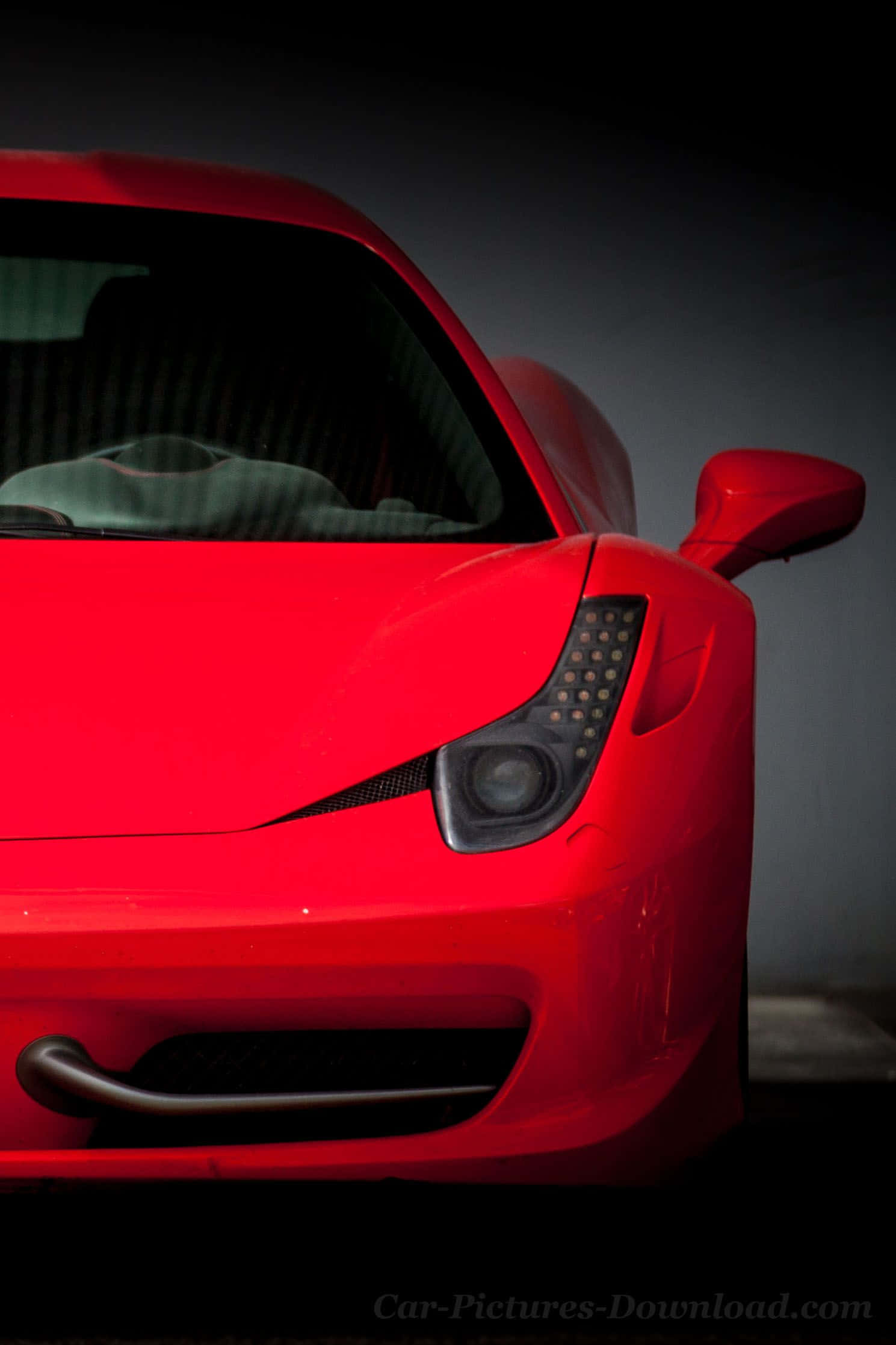 Ferrari iPhone 桌布 壁紙 — 鮮紅色法拉利跑車前四分之一部分的特寫，時尚的頭燈和通過車窗可見的碳纖維內飾。