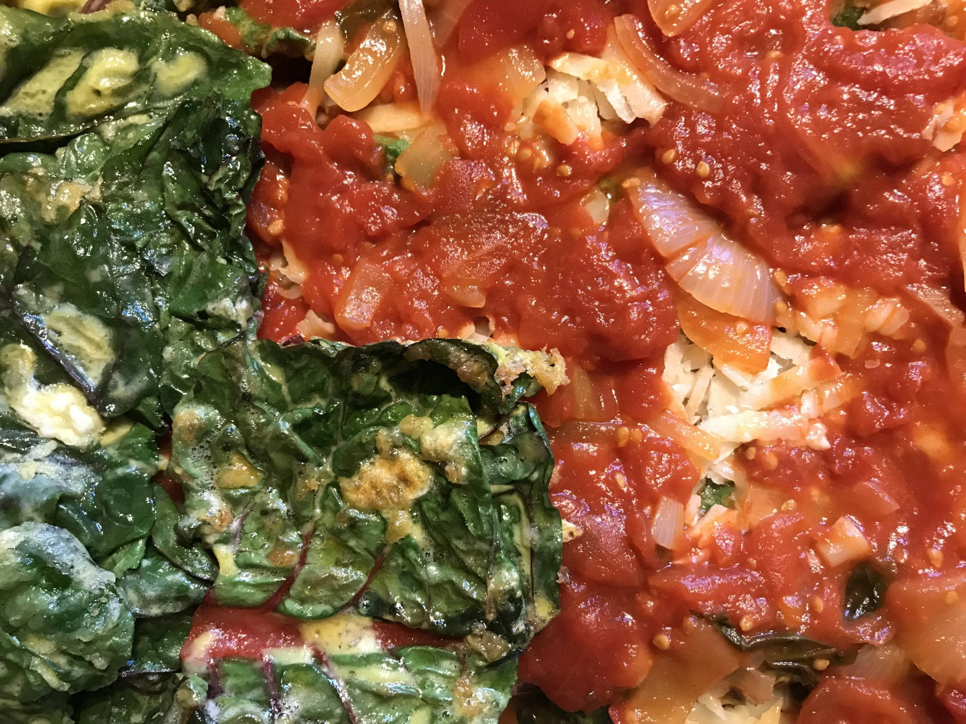 tomato 桌布 壁紙 — 鮮紅色番茄醬配洋蔥和枯萎的綠色菠菜葉的特寫。