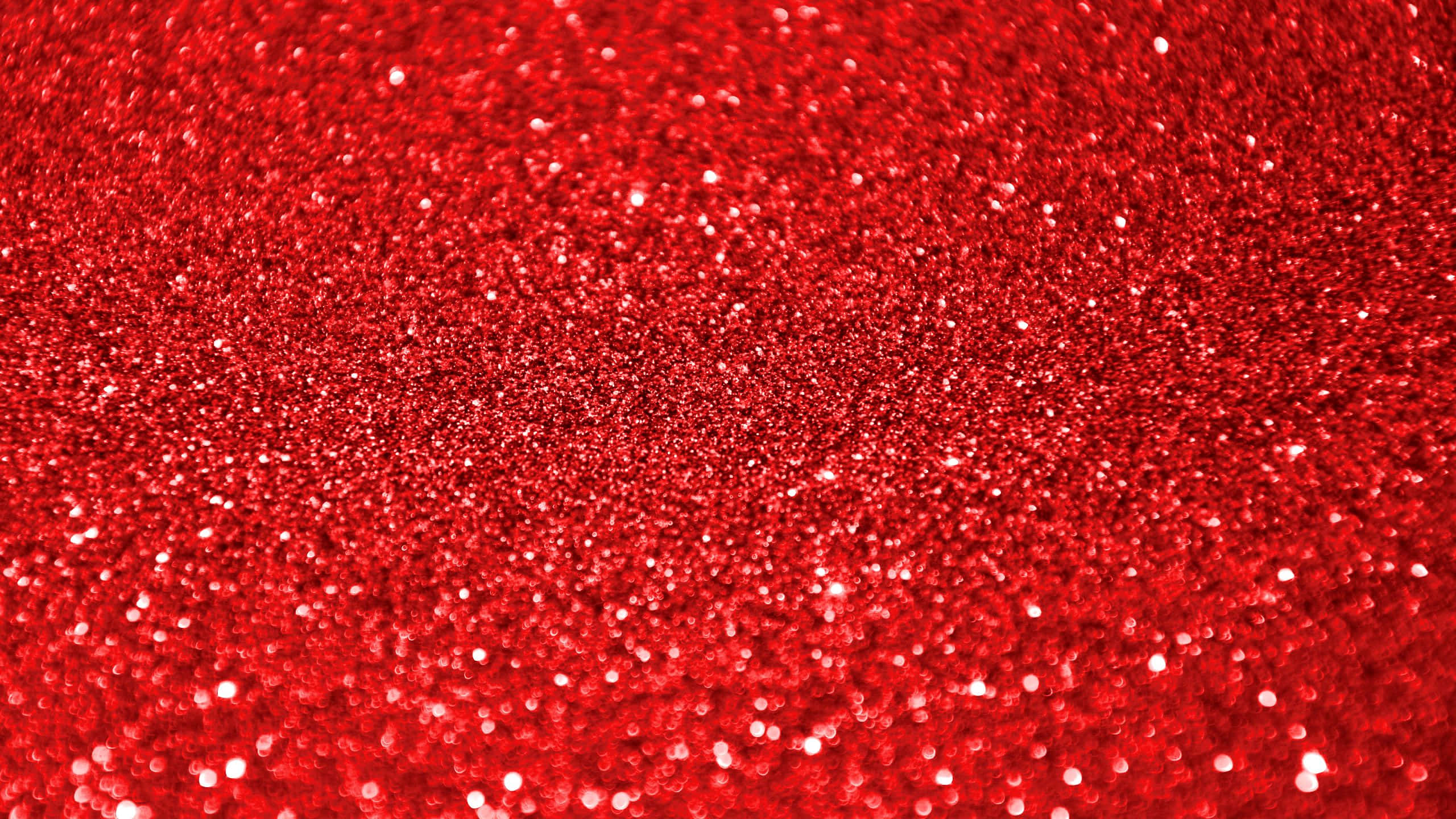 High Resolution Red 桌布 壁紙 — 鮮紅色閃粉的特寫，帶有閃爍亮點，營造出節日氣氛和引人注目的質感。