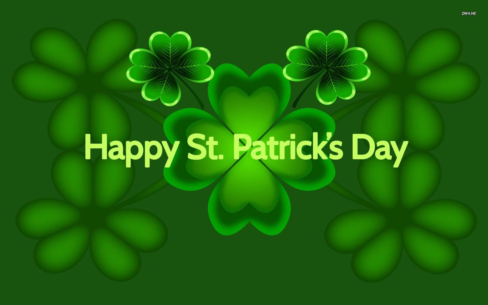 St Patrick's Day 桌布 壁紙 — 鮮綠色三葉草帶有發光輪廓，在深綠色背景上框住節日文字。
