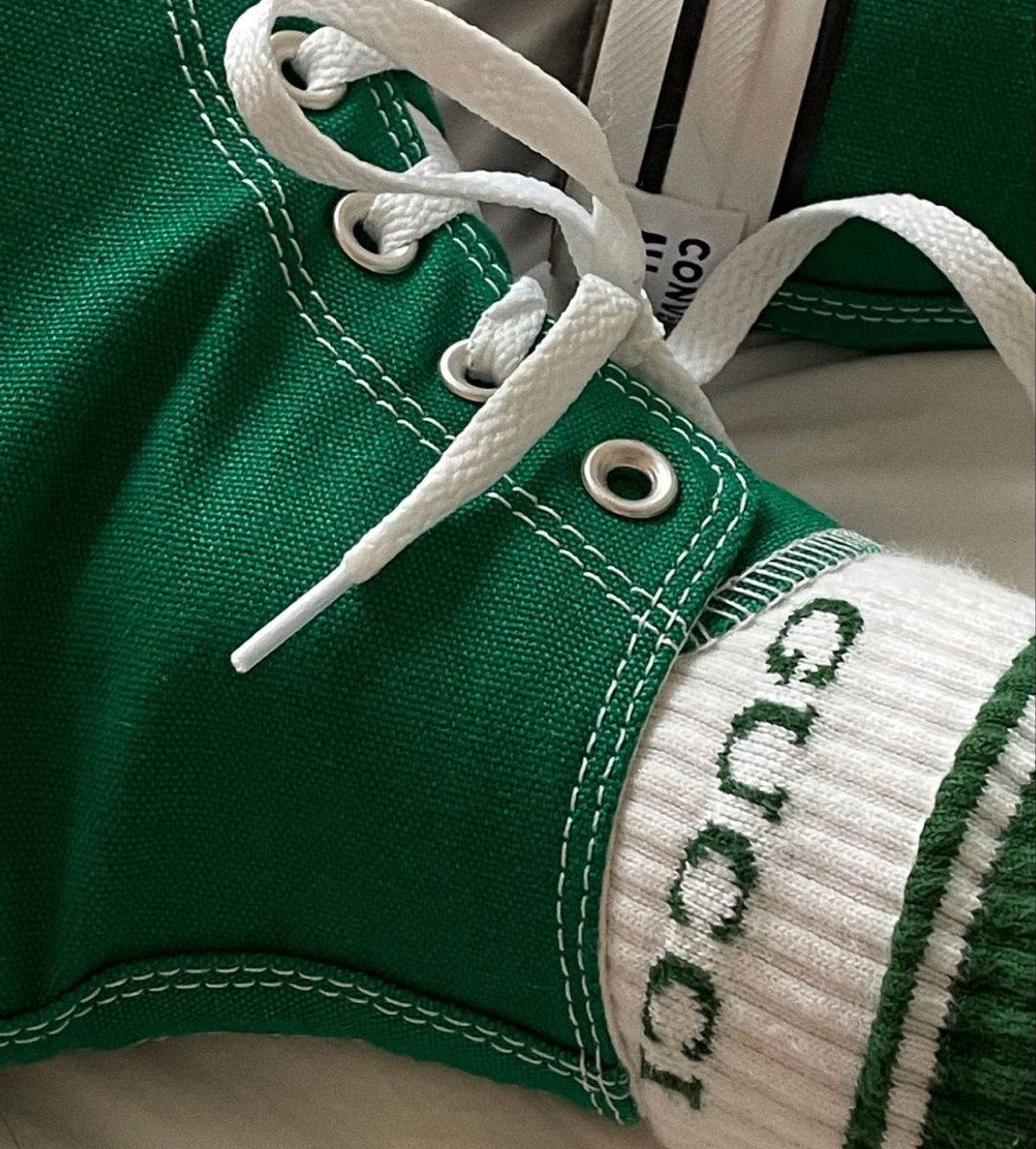 Green Shoes 桌布 壁紙 — 鮮綠色帆布運動鞋特寫，配有白色鞋帶和縫線，搭配帶有綠色Gucci標誌的白色襪子。
